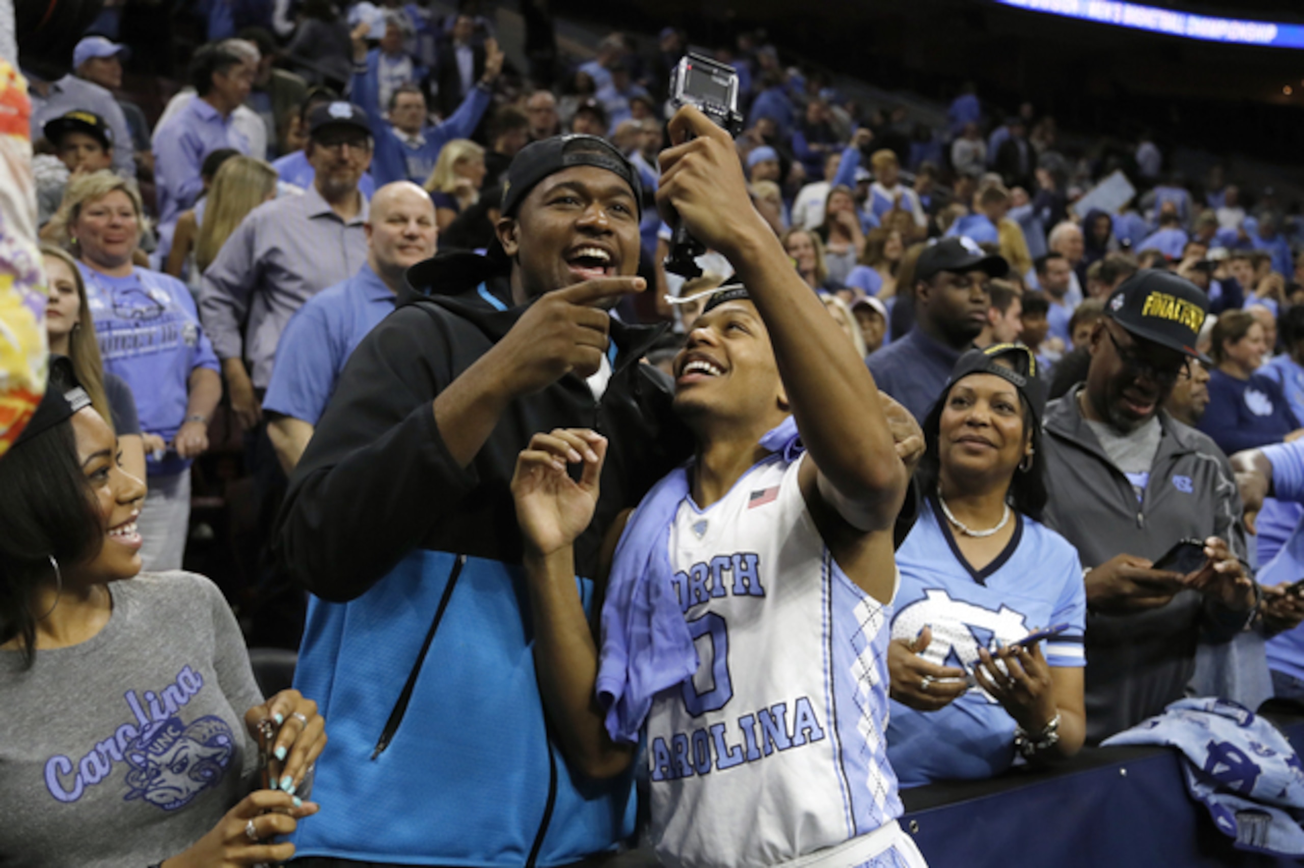 Nate Britt Jr., right, celebrates with his adopted brother Kris Jenkins after the Tar Heels' win in the regional final.