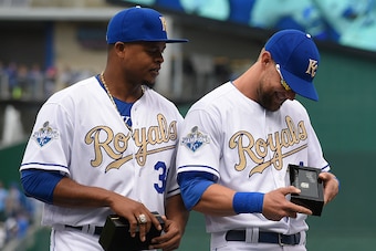 KANSAS CITY, MO - APRIL 5:  Alex Gordon #4 of the Kansas City Royals looks at his World Series Championship ring with Edinson Volquez #36 during a ceremony prior to a game against the New York Mets at Kauffman Stadium on April 5, 2016 in Kansas City, Miss