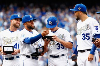 KANSAS CITY, MISSOURI - APRIL 05: Danny Duffy #41, Kelvin Herrera #40, Kris Medlen #39 and Eric Hosmer #35 of the Kansas City Royals inspect their 2015 World Series Championship rings during a ring ceremony prior to the game between the Royals and the New