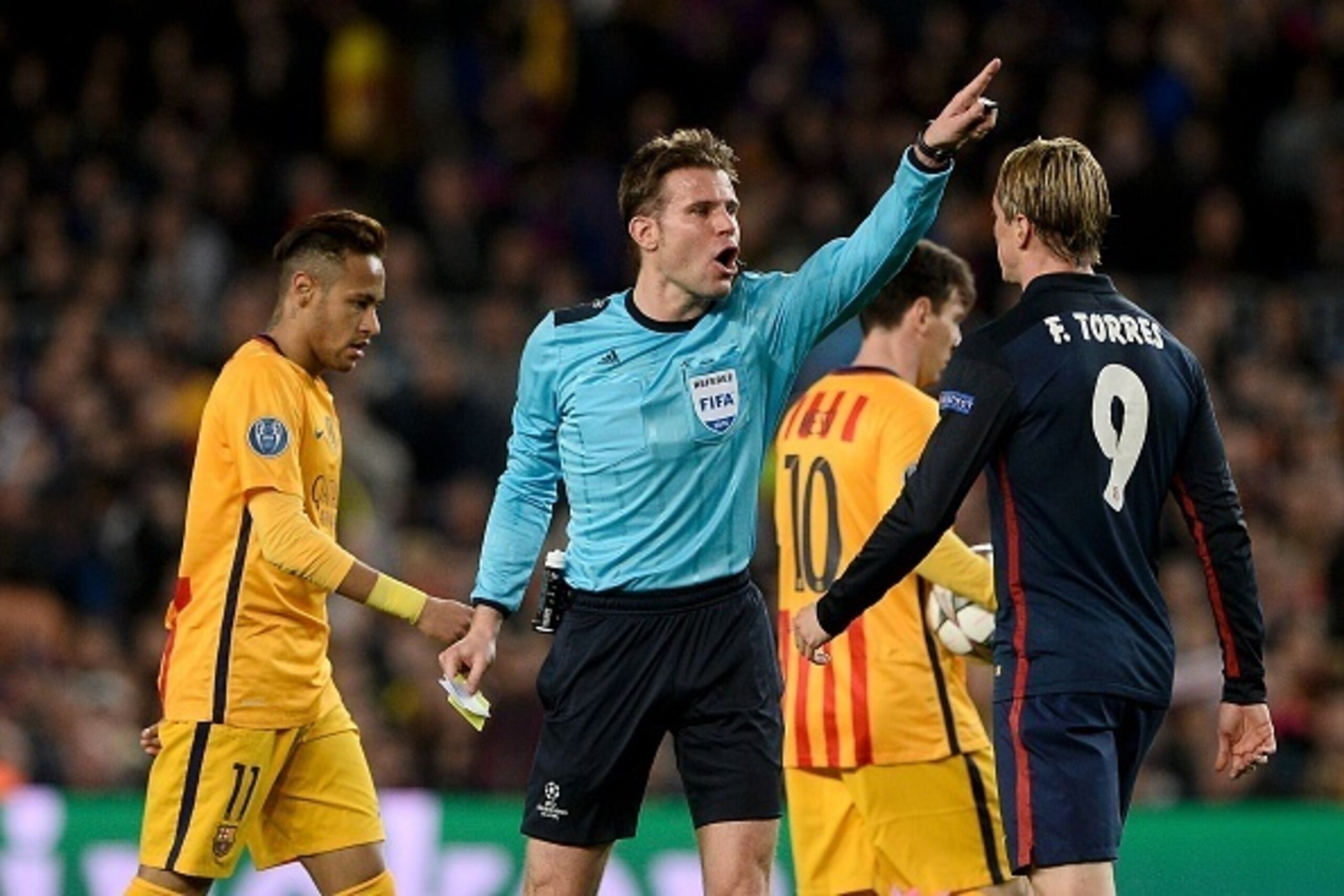 German referee Felix Brych (C) gestures after showing a yellow card to Atletico Madrid's forward Fernando Torres (R) during the UEFA Champions League quarter finals first leg football match FC Barcelona vs Atletico de Madrid at the Camp Nou stadium in Bar German referee Felix Brych (C) gestures after showing a yellow card to Atletico Madrid's forward Fernando Torres (R) during the UEFA Champions League quarter finals first leg football match FC Barcelona vs Atletico de Madrid at the Camp Nou stadium in Bar