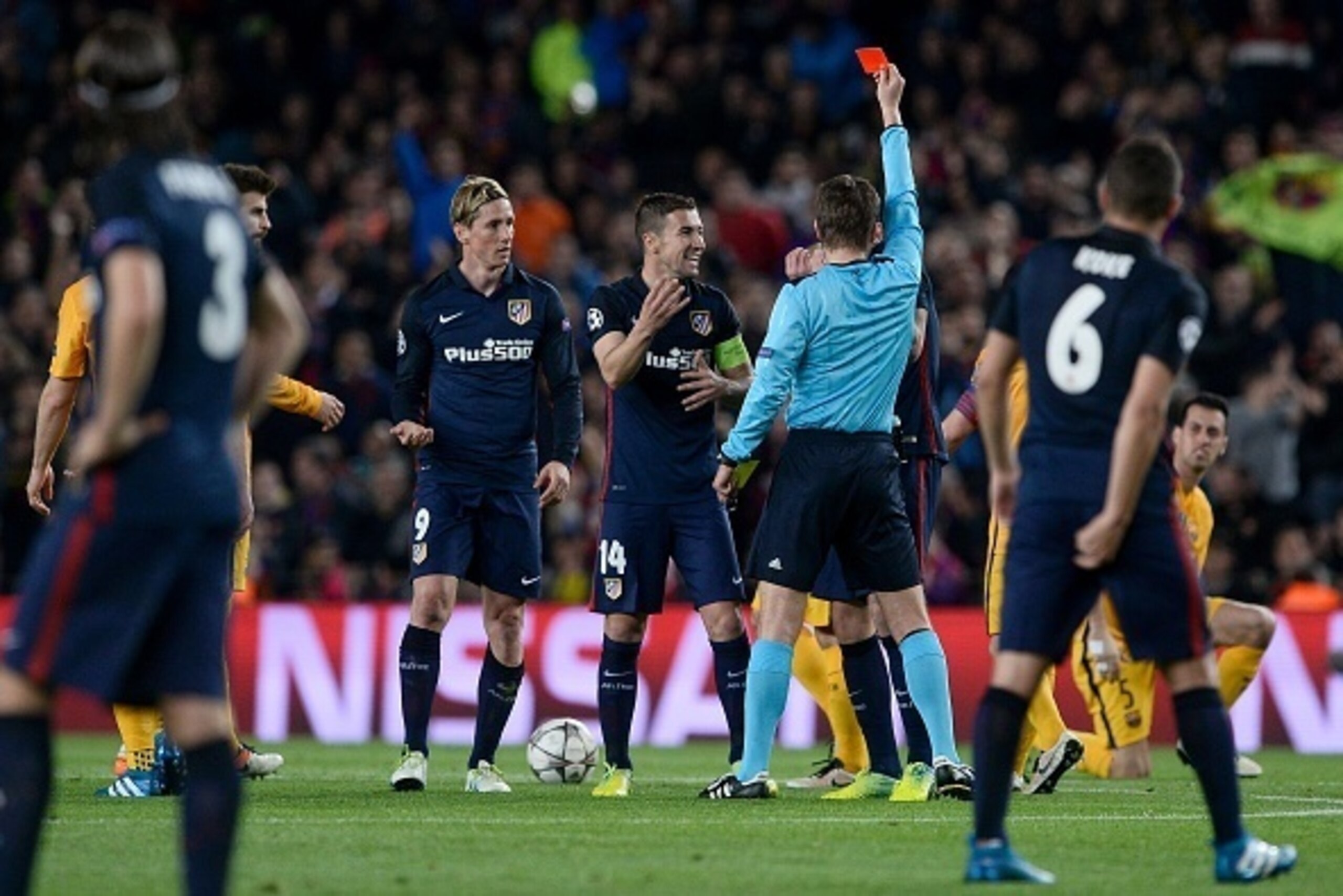 German referee Felix Brych (C) shows a red card to Atletico Madrid's forward Fernando Torres (R) during the UEFA Champions League quarter finals first leg football match FC Barcelona vs Atletico de Madrid at the Camp Nou stadium in Barcelona on April 5, 2