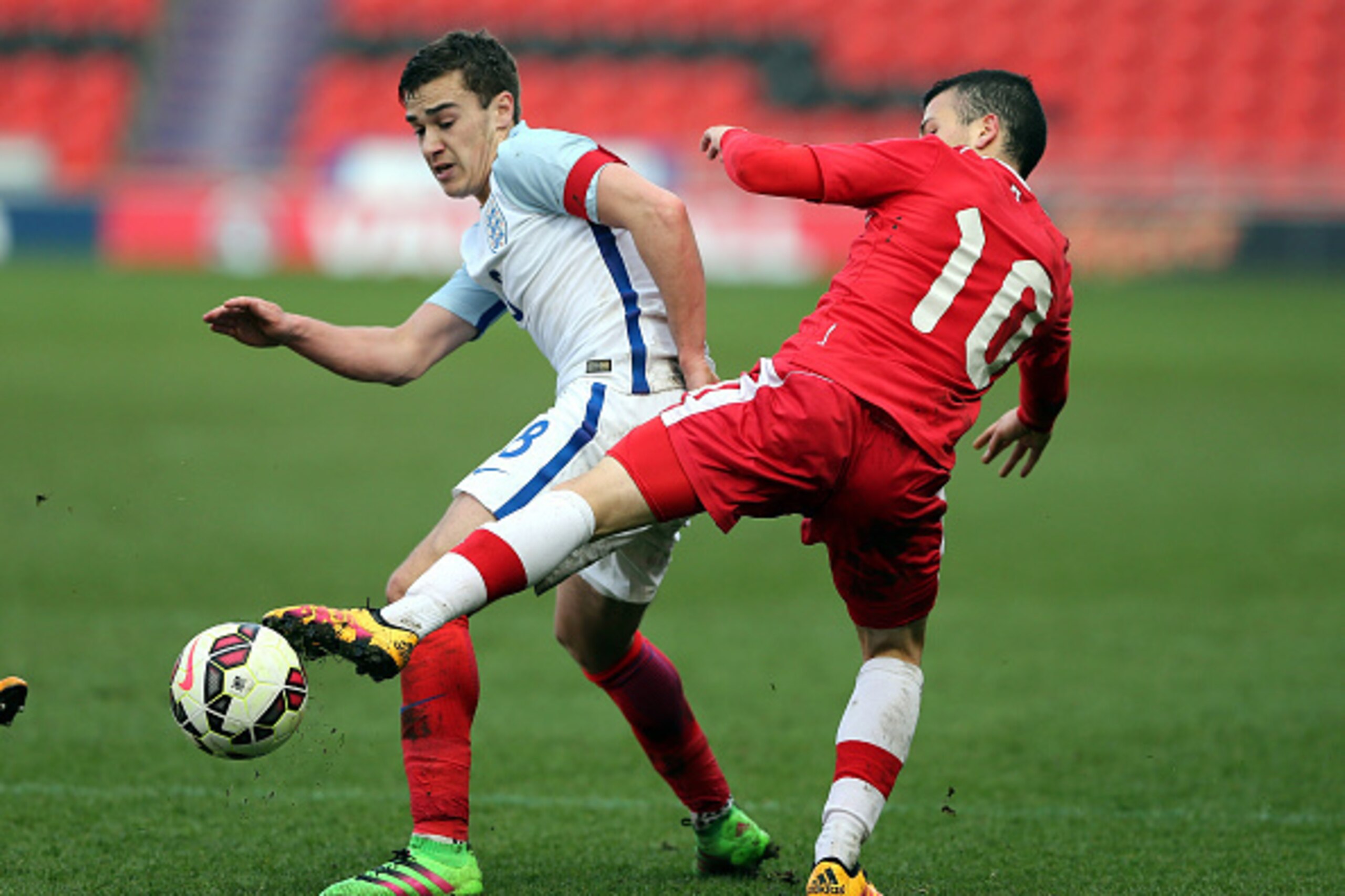 DONCASTER, ENGLAND - MARCH 27:  Harry Winks of England (L) challenged by Marco Bustos of Canada during the U20 International Friendly match between England and Canada at the Keepmoat Stadium on March 27, 2016 in Doncaster, England.  (Photo by Nigel Roddis
