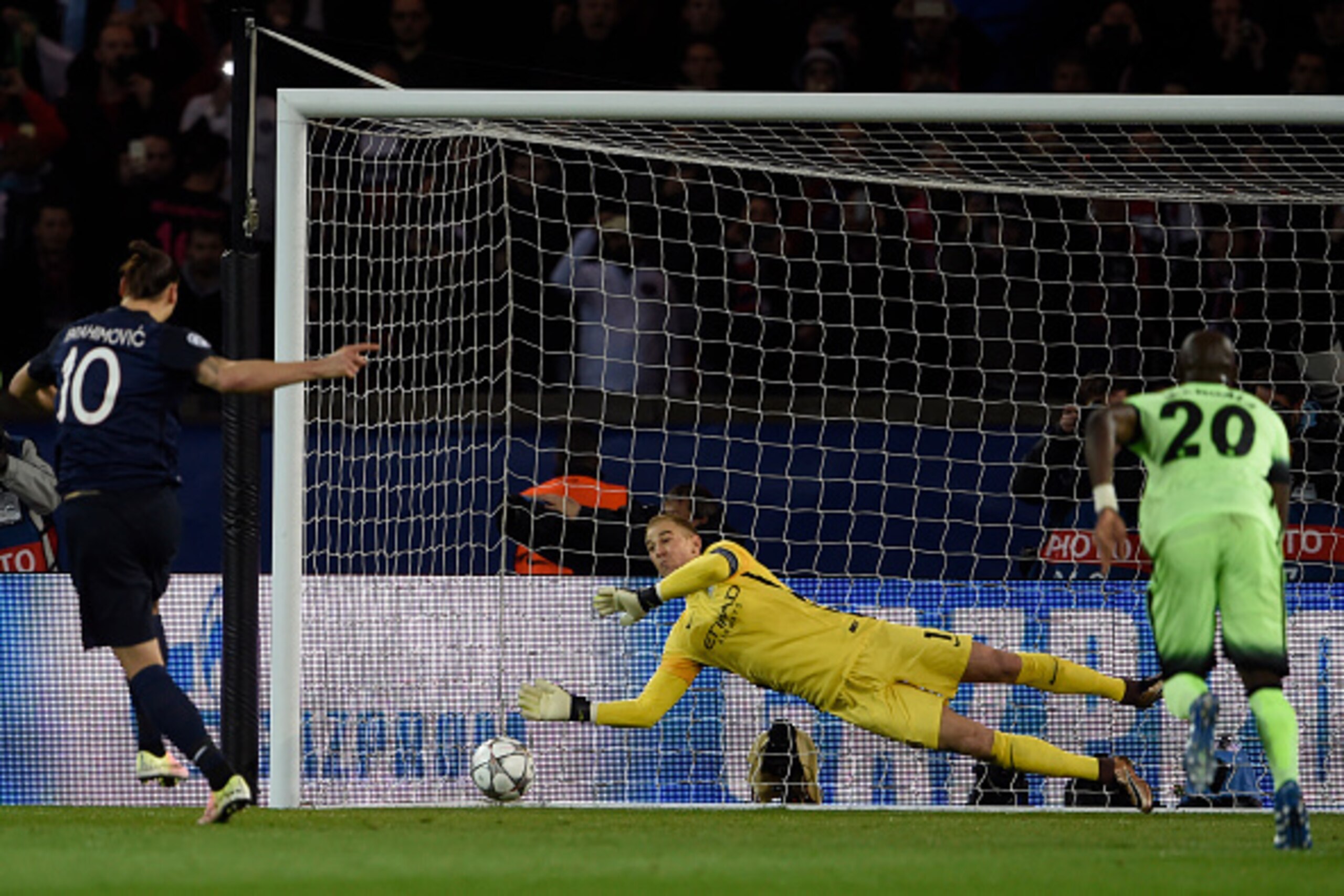 Paris Saint-Germain's Swedish forward Zlatan Ibrahimovic  (L) shoots as Manchester City's English goalkeeper Joe Hart  (C) stops the ball during the UEFA Champions League quarter final football match between Paris Saint Germain (PSG) and Manchester City o