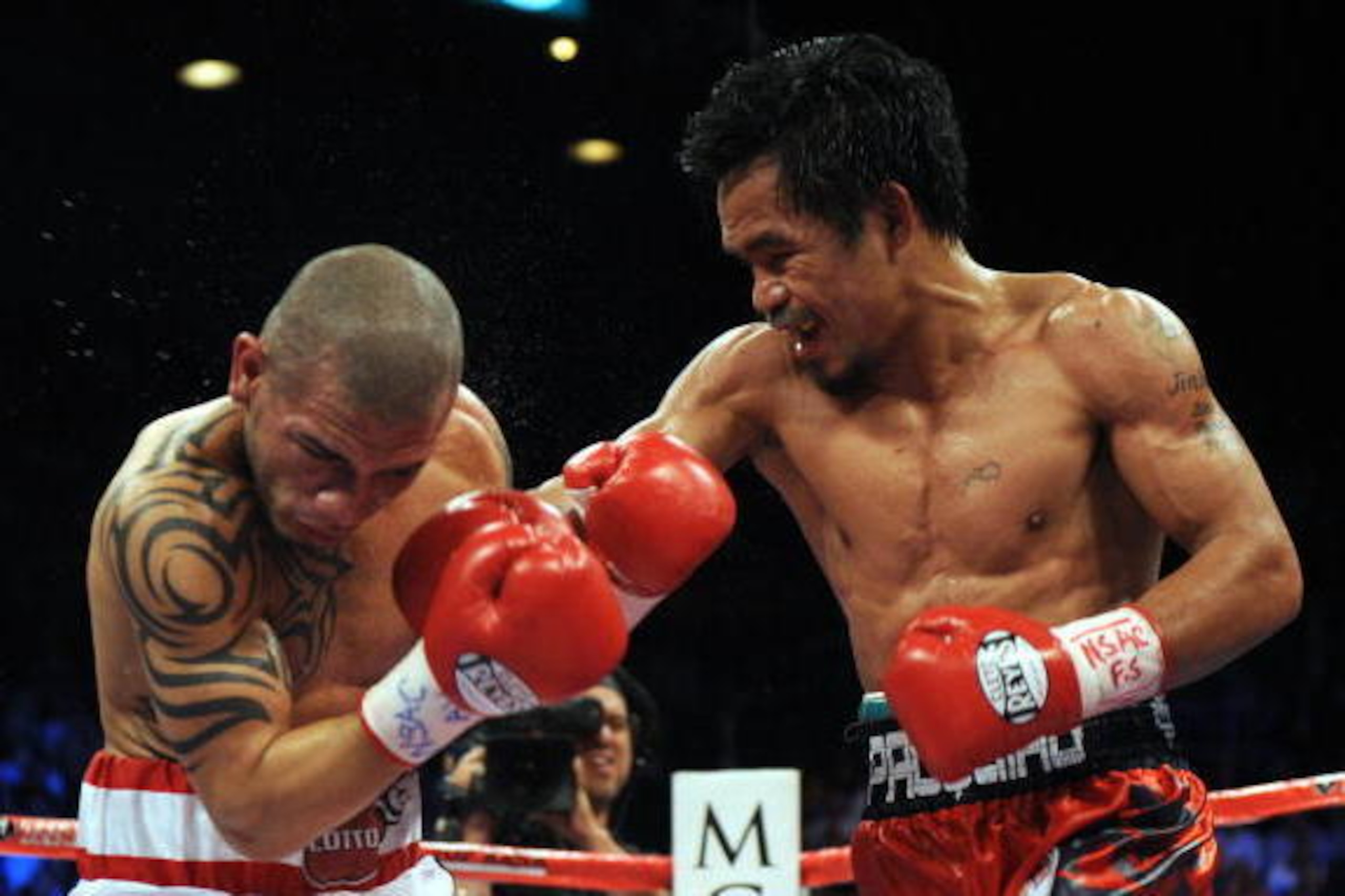 Manny Pacquiao of the Philippines (R) punches Miguel Cotto of Puerto Rico during their WBO welterweight title fight on November 14, 2009  at the MGM Grand in Las Vegas, Nevada.   AFP PHOTO / GABRIEL BOUYS (Photo credit should read GABRIEL BOUYS/AFP/Getty 