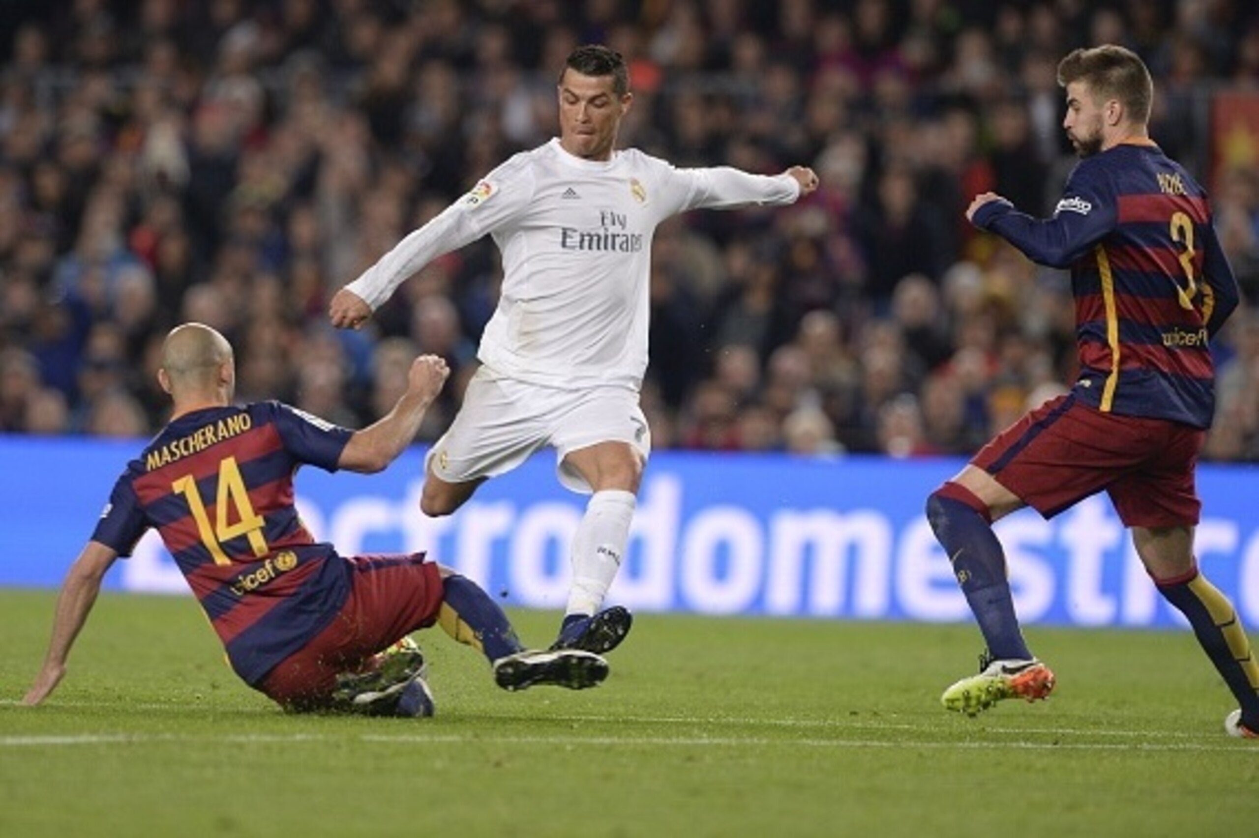 Real Madrid's Portuguese forward Cristiano Ronaldo (C) vies with Barcelona's defender Gerard Pique (R) and Barcelona's Argentinian defender Javier Mascherano during the Spanish league 'Clasico' football match FC Barcelona vs Real Madrid CF at the Camp Nou