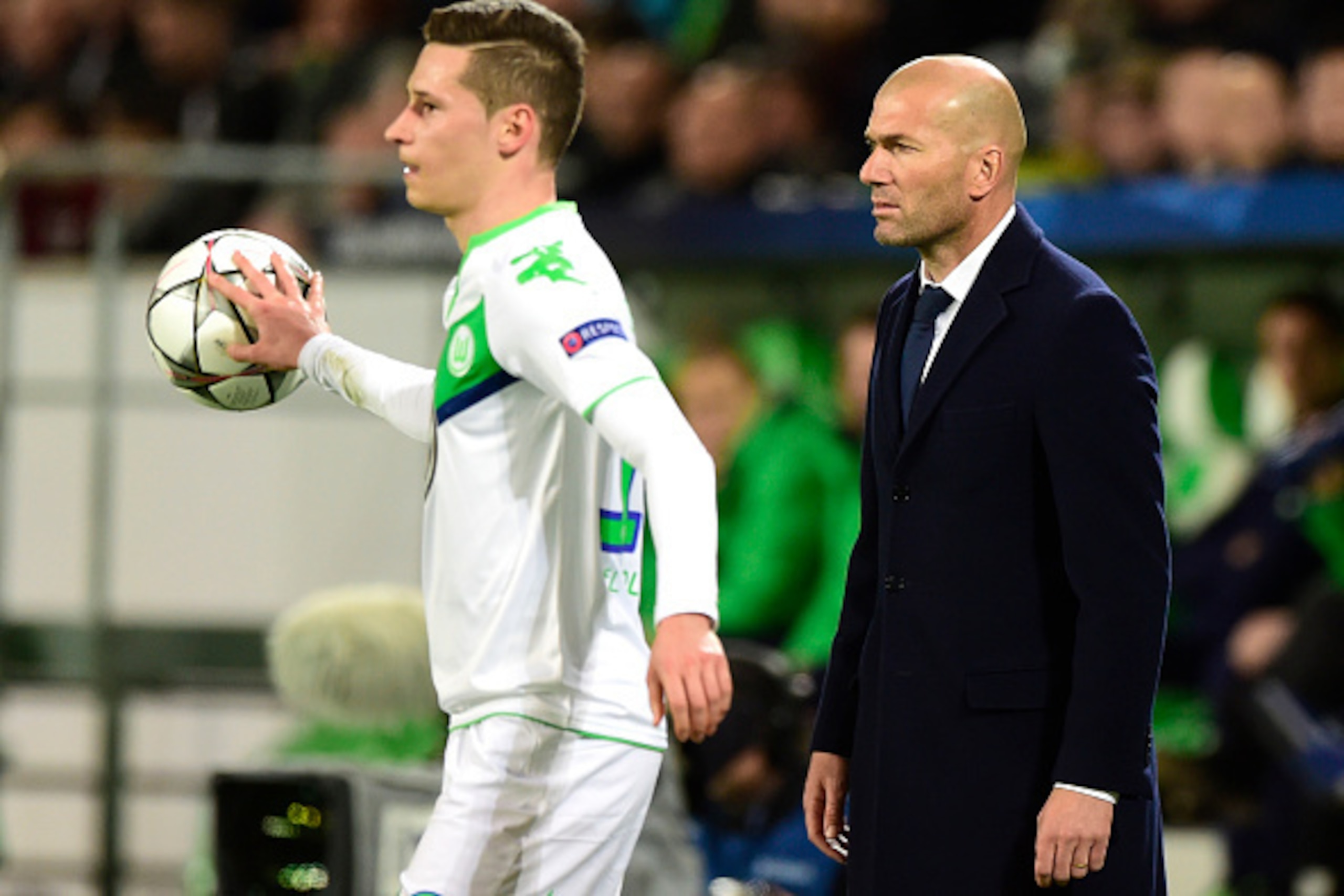 Real Madrid's French coach Zinedine Zidane (r) stands by Wolfsburg's midfielder Julian Draxler during the UEFA Champions League quarter-final, first-leg football match between VfL Wolfsburg and Real Madrid on April 6, 2016 in Wolfsburg, northern Germany. 