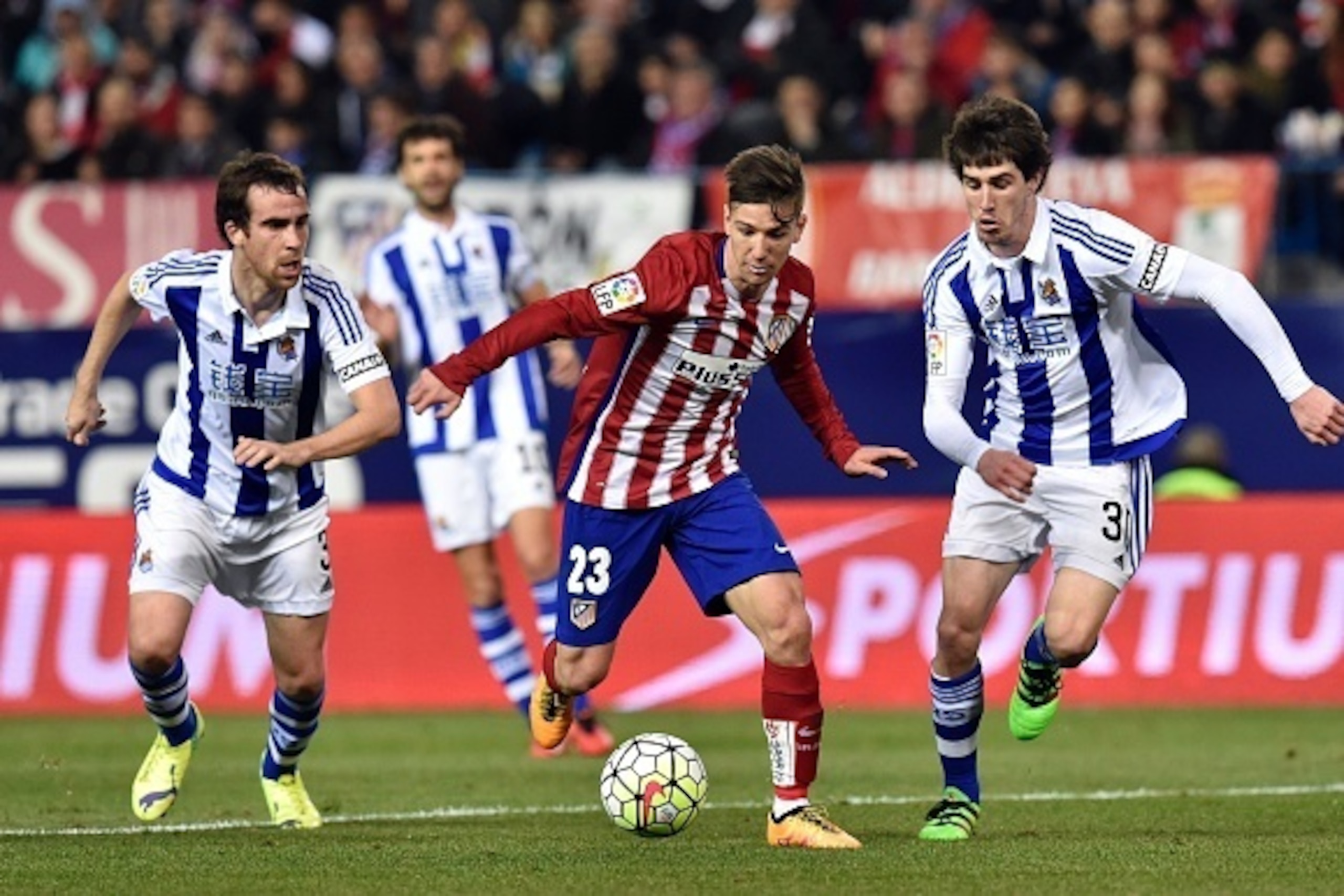 Atletico Madrid's Argentinian forward Luciano Vietto (C) vies with  Real Sociedad's defender Mikel Gonzalez (L) and Real Sociedad's defender Aritz Elustondo during the Spanish league football match Club Atletico de Madrid vs Real Sociedad de Futbol at the