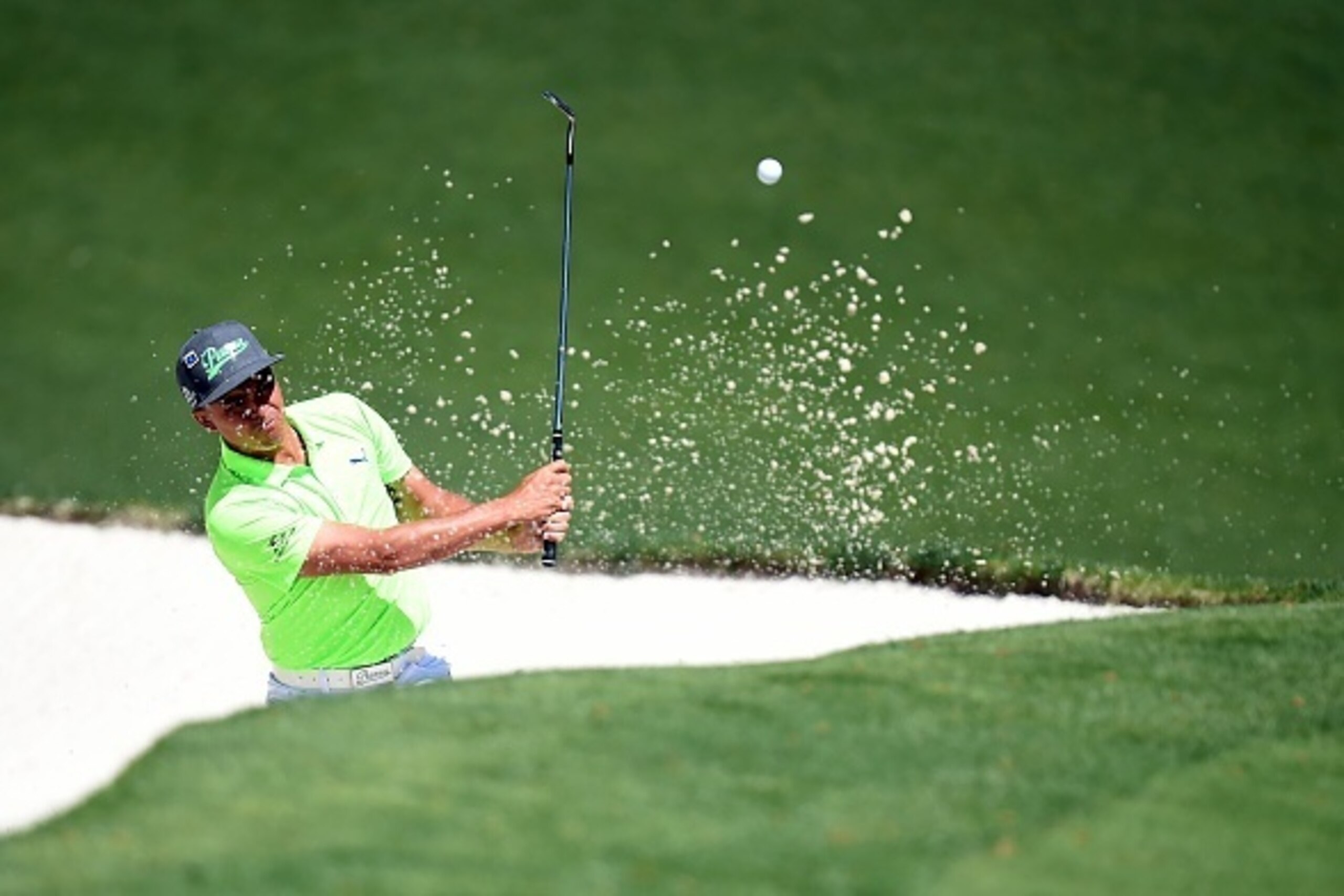 US golfer Rickie Fowler hits out of a bunker during Round 1 of the 80th Masters Golf Tournament at the Augusta National Golf Club on April 7, 2016, in Augusta, Georgia.

 / AFP / Jim Watson        (Photo credit should read JIM WATSON/AFP/Getty Images)
