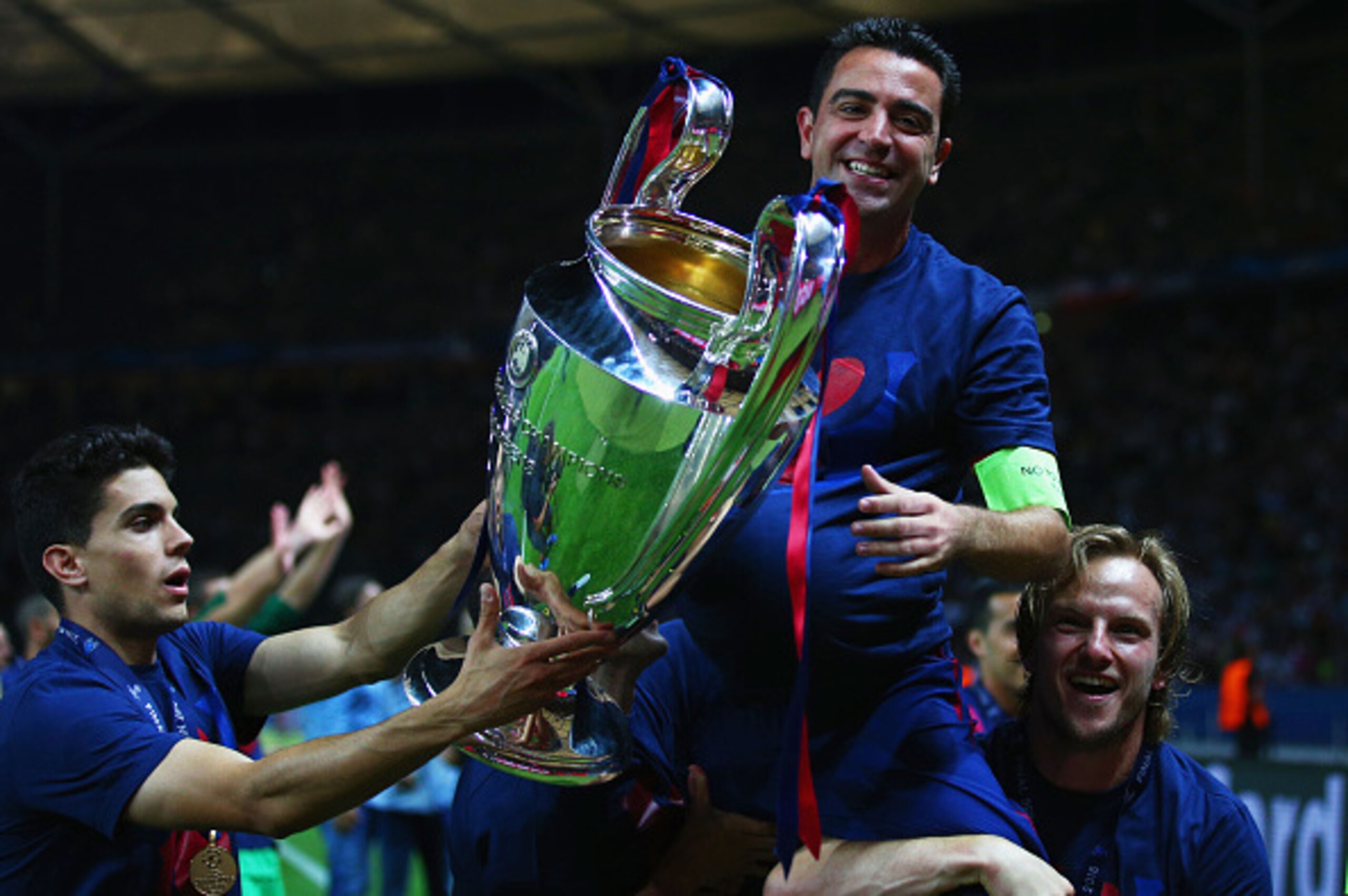 BERLIN, GERMANY - JUNE 06: Xavi Hernandez of Barcelona celebrates with Ivan Rakitic (R) and the trophy after the UEFA Champions League Final between Juventus and FC Barcelona at Olympiastadion on June 6, 2015 in Berlin, Germany.  (Photo by Paul Gilham/Get