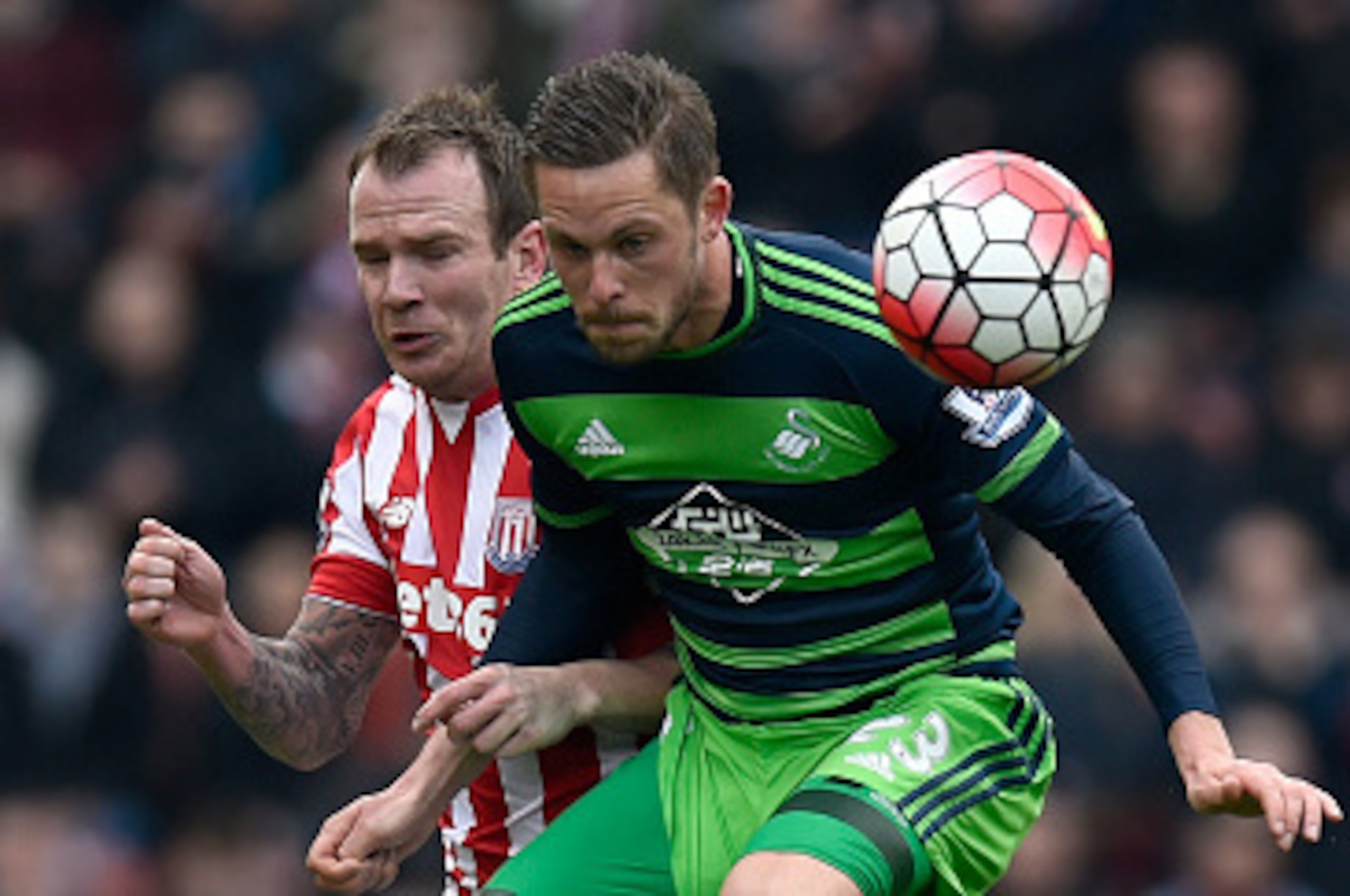 STOKE ON TRENT, ENGLAND - APRIL 02:  Stoke player Glenn Whelan (l) challenges Gylfi Sigurdsson of Swansea during the Barclays Premier League match between Stoke City and Swansea City at Britannia Stadium on April 2, 2016 in Stoke on Trent, England.  (Phot