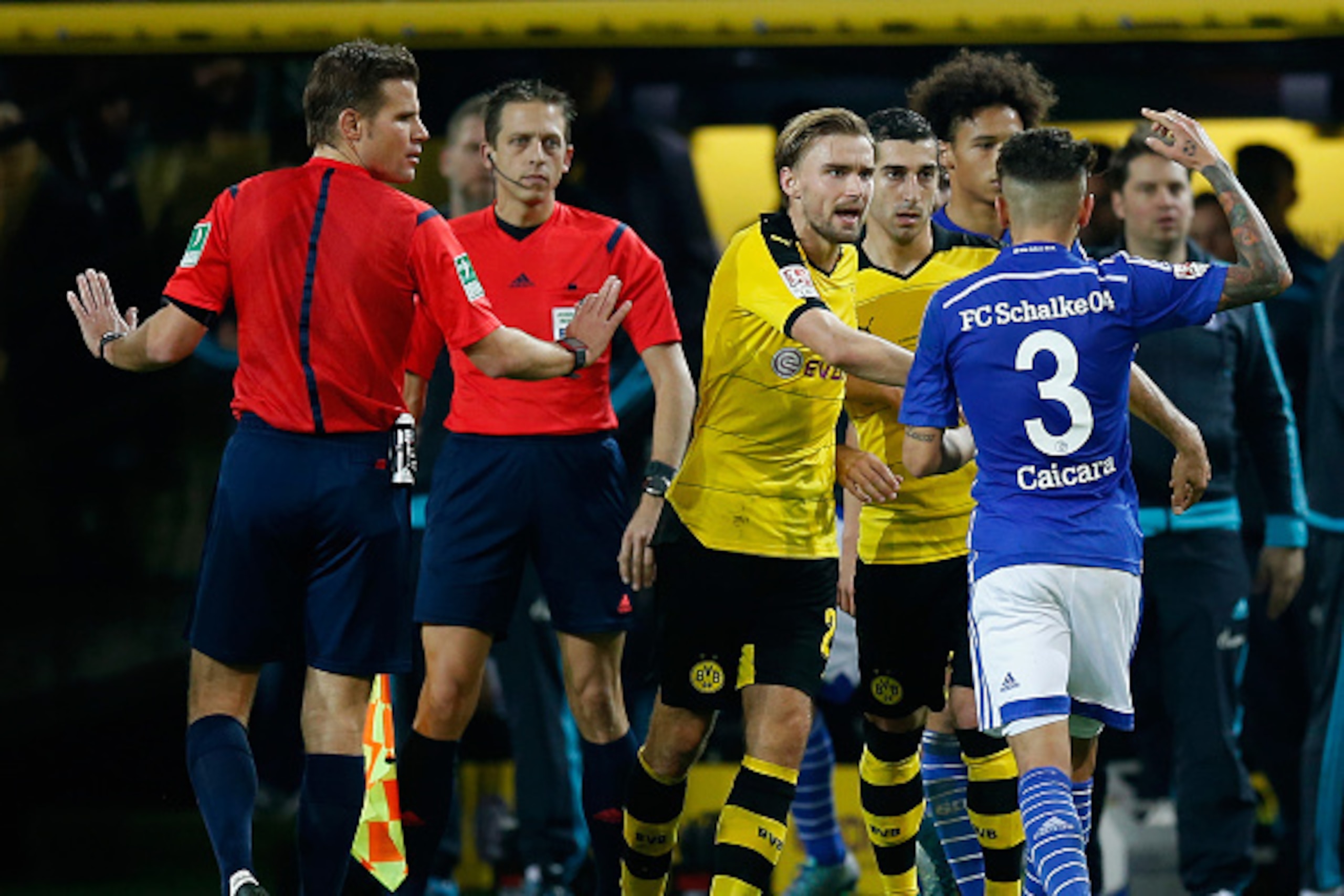 DORTMUND, GERMANY - NOVEMBER 08:  Felix Brych (L) watches Caicara of Schalke and Marcel Schmelzer of Dortmund quarrel during the Bundesliga match between Borussia Dortmund and FC Schalke 04 at Signal Iduna Park on November 8, 2015 in Dortmund, Germany.  (