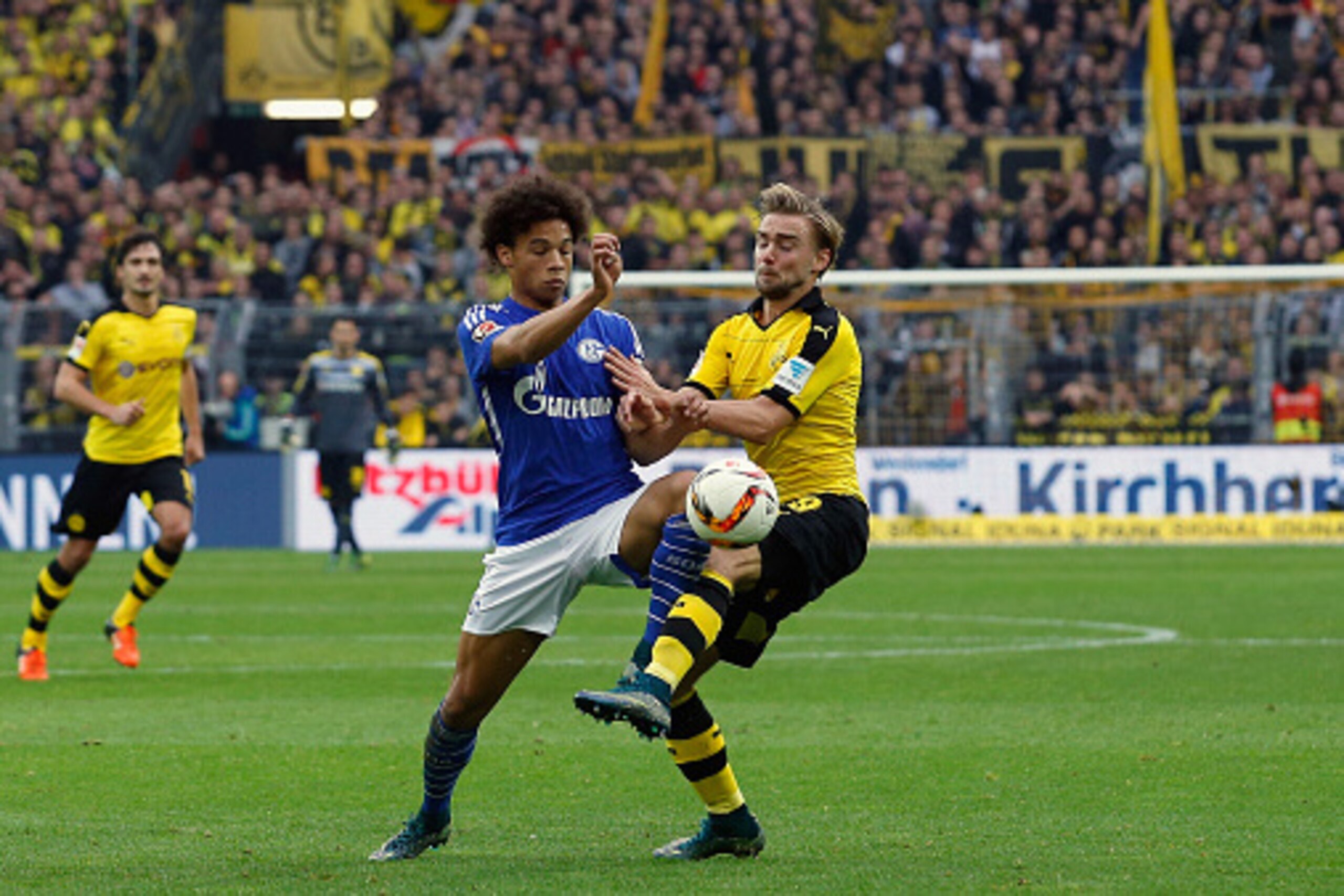 DORTMUND, GERMANY - NOVEMBER 08:  Leroy Sane of Schalke battles for the ball with Marcel Schmelzer (R) of Dortmund during the Bundesliga match between Borussia Dortmund and FC Schalke 04 at Signal Iduna Park on November 8, 2015 in Dortmund, Germany.  (Pho