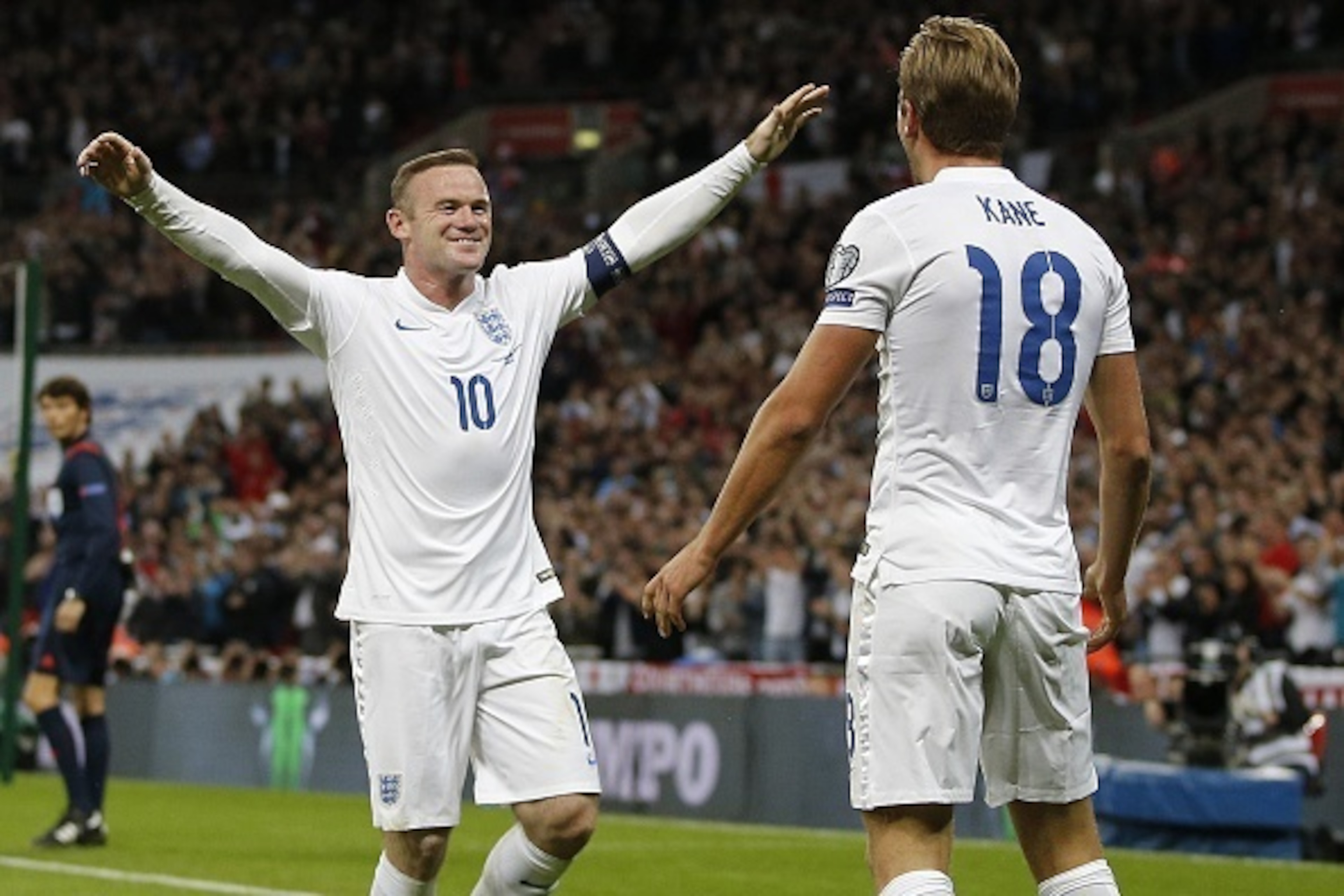England's striker Wayne Rooney (L) reacts as England's Harry Kane celebrates scoring during the Euro 2016 qualifying group E football match between England and Switzerland at Wembley Stadium in west London on September 8, 2015.    AFP PHOTO / ADRIAN DENNI