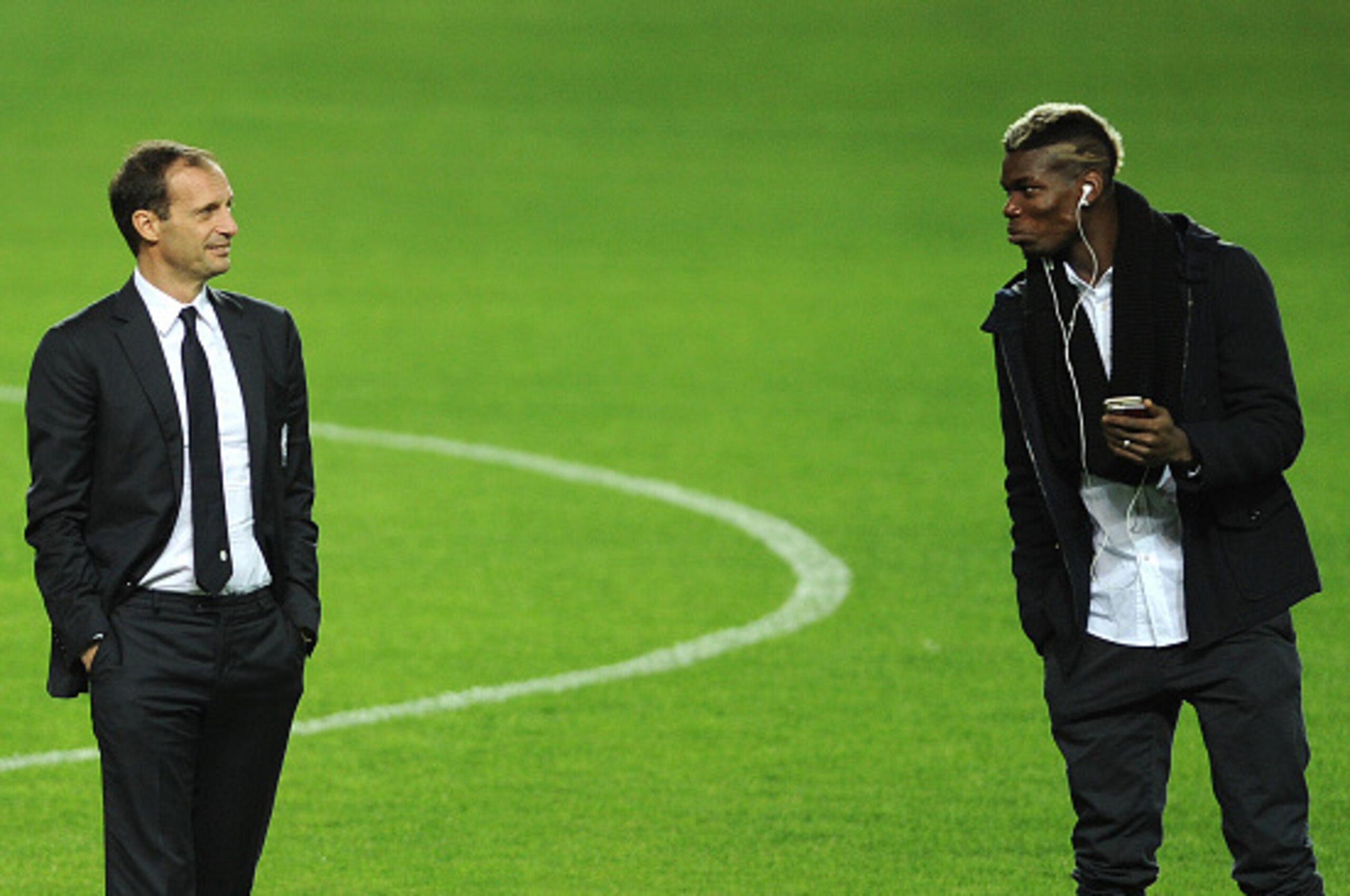 Juventus's French midfielder Paul Pogba (R) speaks with Juventus's coach Italian Massimiliano Allegri (L) at the Ramon Sanchez Pizjuan in Sevilla on December 7, 2015, on the eve of the UEFA Champions League Group D football match Sevilla FC vs Juventus.  