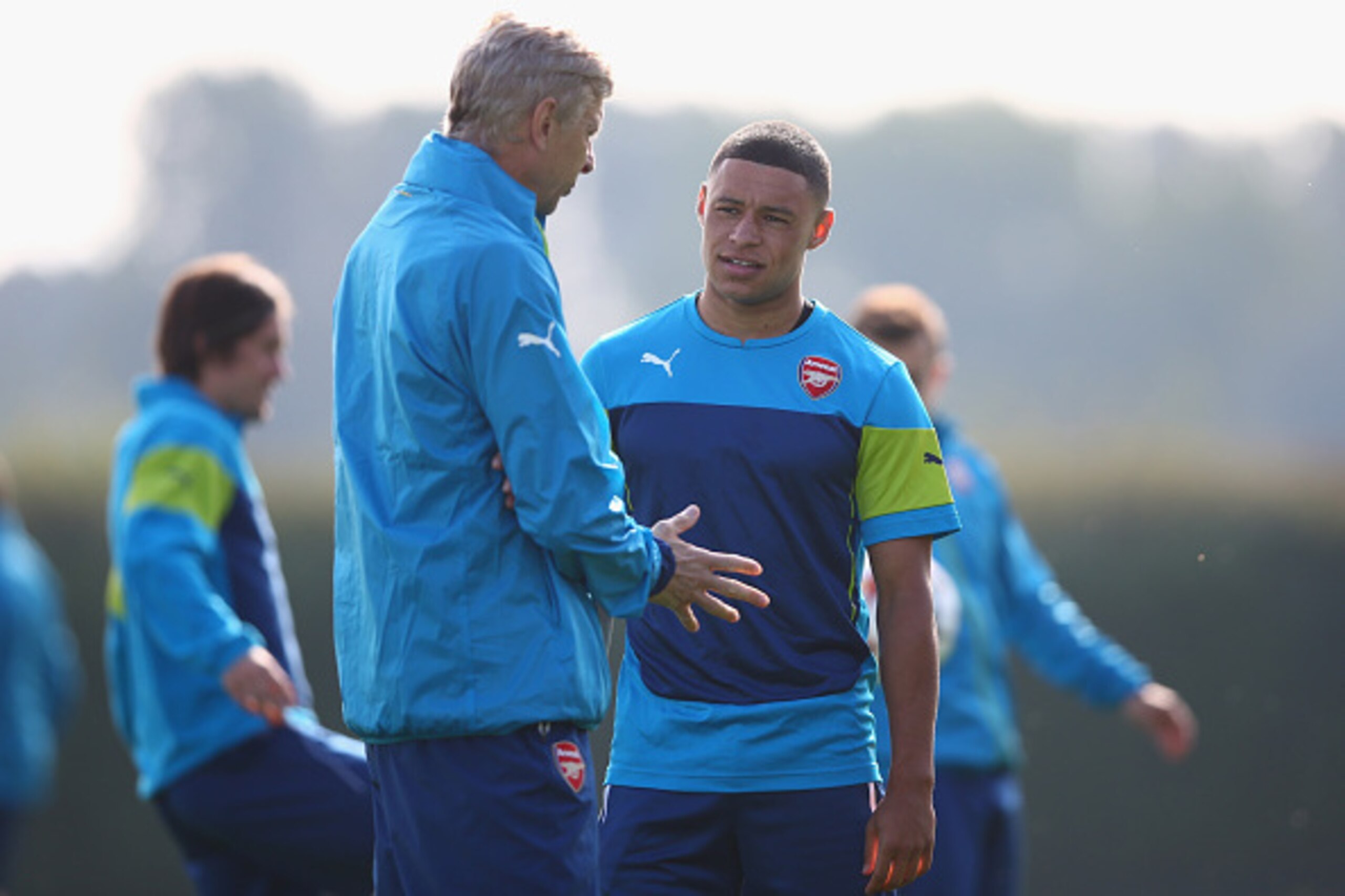 ST ALBANS, ENGLAND - SEPTEMBER 30:  Manager Arsene Wenger of Arsenal talks to Alex Oxlade-Chamberlain during an Arsenal training session ahead of their UEFA Champions League Group D match against Galatasaray at London Colney on September 30, 2014 in St Al