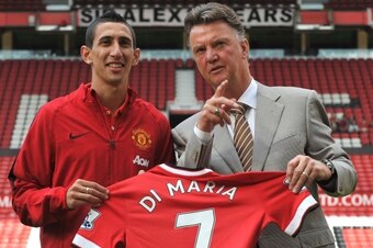 Manchester United's Dutch manager Louis van Gaal (R) poses with Manchester United's newly-signed Argentinian midfielder Angel di Maria (L) during an official presentation on the pitch at Old Trafford in Manchester, north-west England on August 28, 2014. M