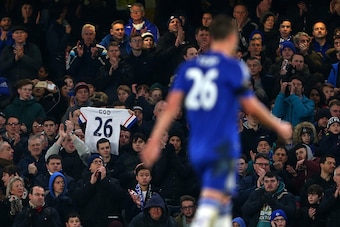 LONDON, ENGLAND - FEBRUARY 13 :  A fan holds up a shirt saying God and the number 26 as John Terry of Chelsea walks past during the Barclays Premier League match between Chelsea and Newcastle United at Stamford Bridge on February 13, 2016 in London, Engla
