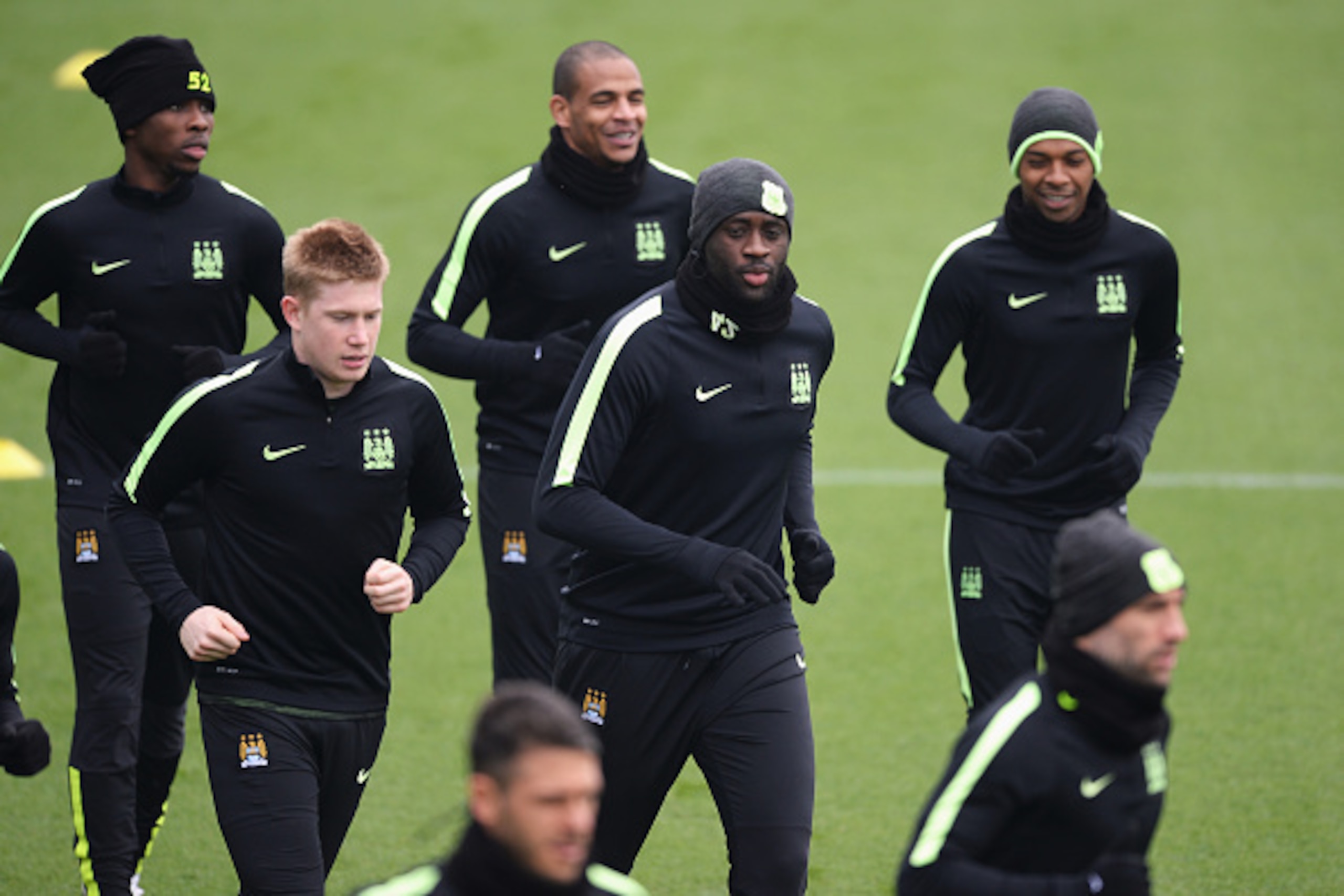 MANCHESTER, ENGLAND - APRIL 11:  Kevin de Bruyne and Yaya Toure of Manchester City warm up with team mates during a training session ahead of the UEFA Champions League Quarter Final Second Leg match against Paris Saint-Germain at the Academy training grou