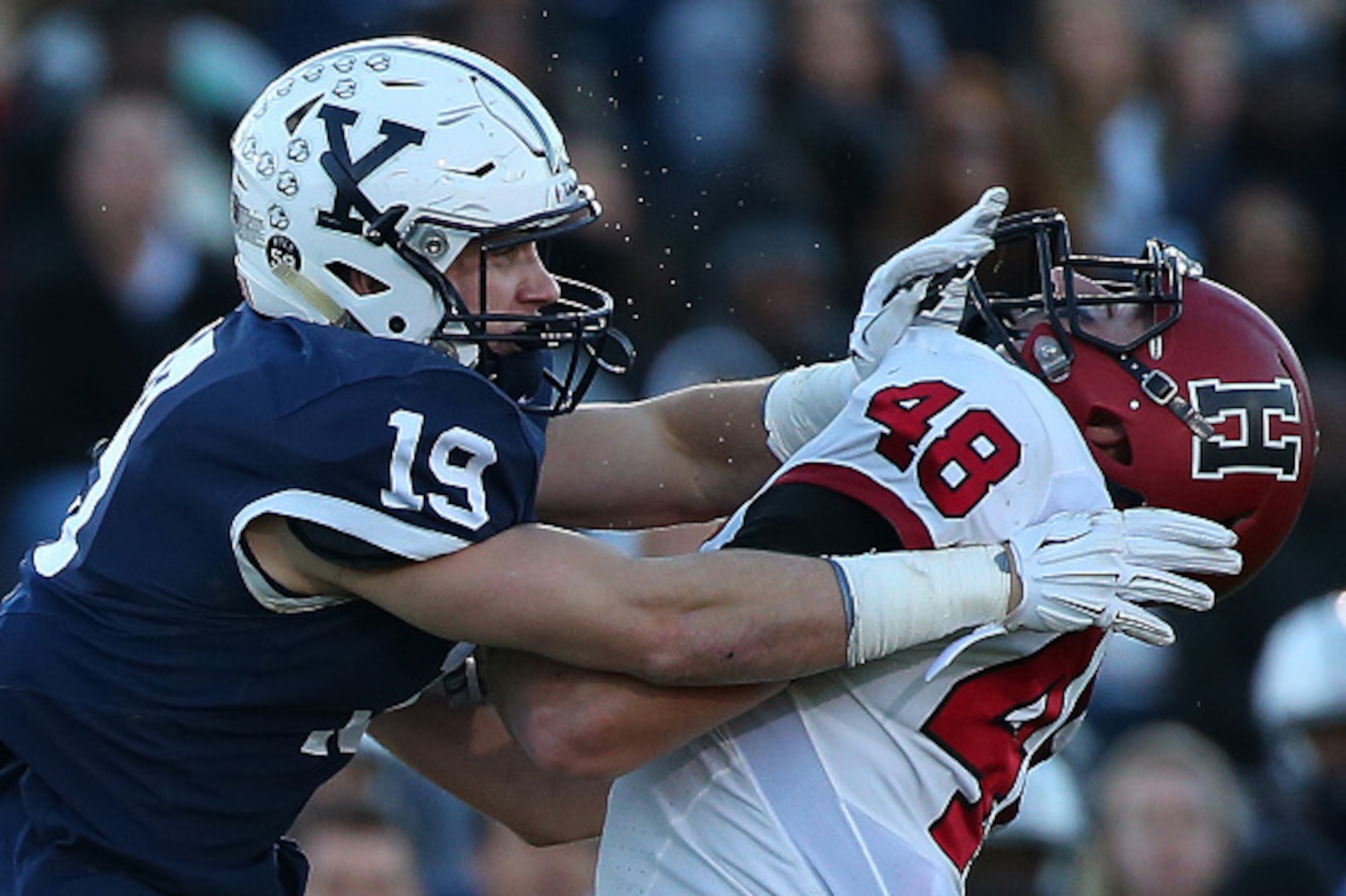 NEW HAVEN, CT - NOVEMBER 21:  Keith Hawk #15 of the Yale Bulldogs collides with Ben Braunecker #48 of the Harvard Crimson in the first half on November 21, 2015 in New Haven, Connecticut. (Photo by Jim Rogash/Getty Images)