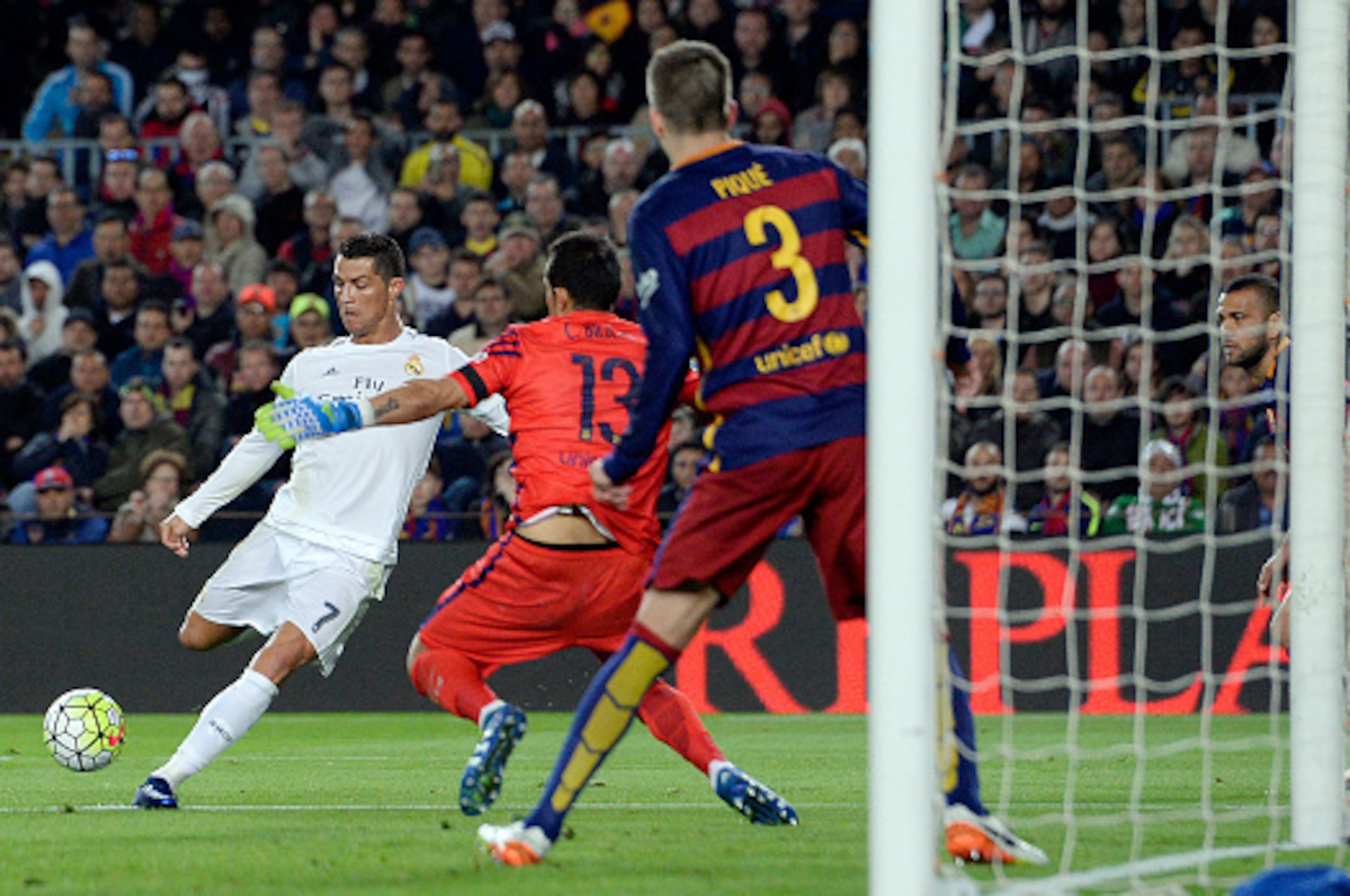 Real Madrid's Portuguese forward Cristiano Ronaldo (L) shoots next to Barcelona's Chilean goalkeeper Claudio Bravo to score a goal during the Spanish league 'Clasico' football match FC Barcelona vs Real Madrid CF at the Camp Nou stadium in Barcelona on Ap