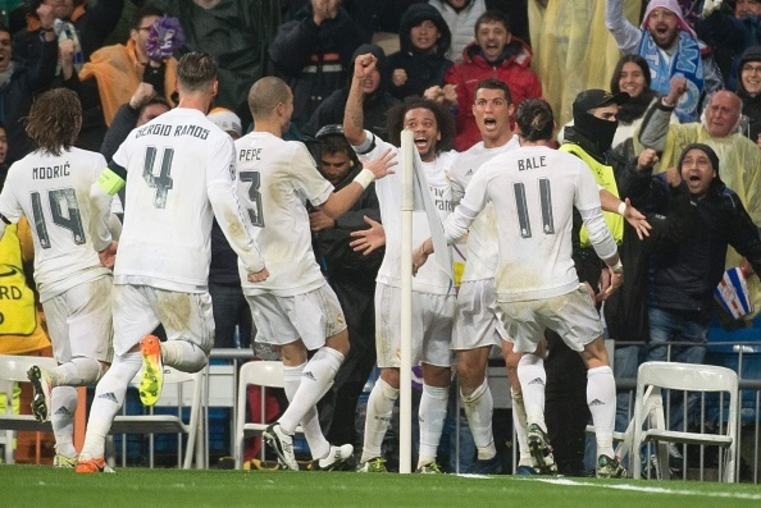 Real Madrid's Portuguese forward Cristiano Ronaldo celebrates after scoring with teammates during the Champions League quarter-final second leg football match Real Madrid vs Wolfsburg at the Santiago Bernabeu stadium in Madrid on April 12, 2016. / AFP / C