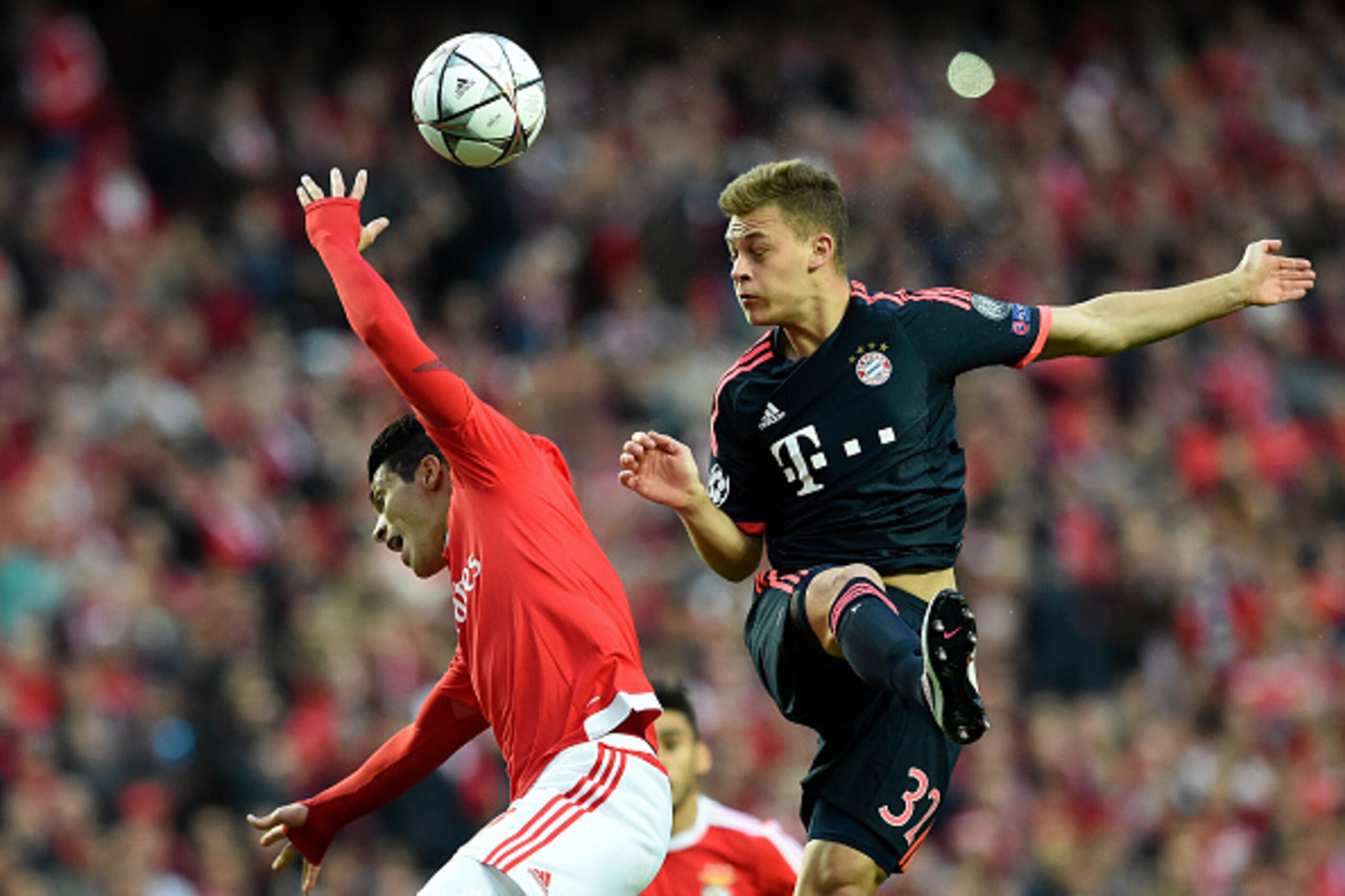 Benfica's Mexican forward Raul Jimenez (L) vies with Bayern Munich's defender Joshua Kimmich during the Champions League quarter-final second leg football match SL Benfica vs Bayern Munchen at the Luz stadium in Lisbon on April 13, 2016. / AFP / FRANCISCO