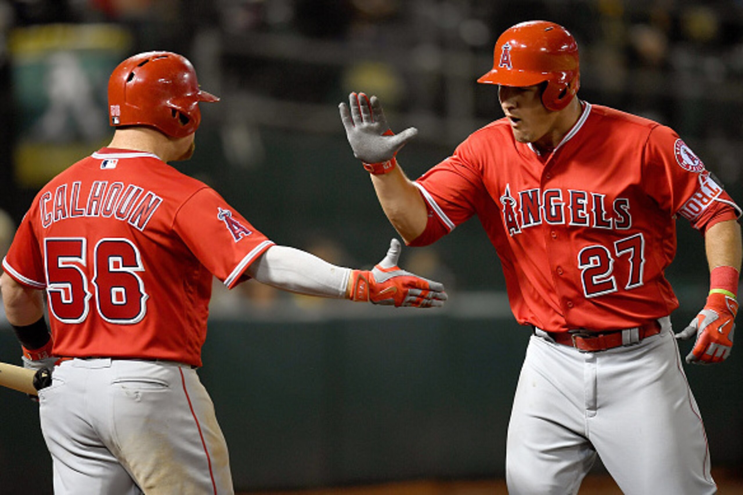 OAKLAND, CALIFORNIA - APRIL 11:  Mike Trout #27 of the Los Angeles Angels of Anaheim is congratulated by Kole Calhoun #56 after Trout hit a two-run homer against the Oakland Athletics in the top of the six inning The Coliseum on April 11, 2016 in Oakland,