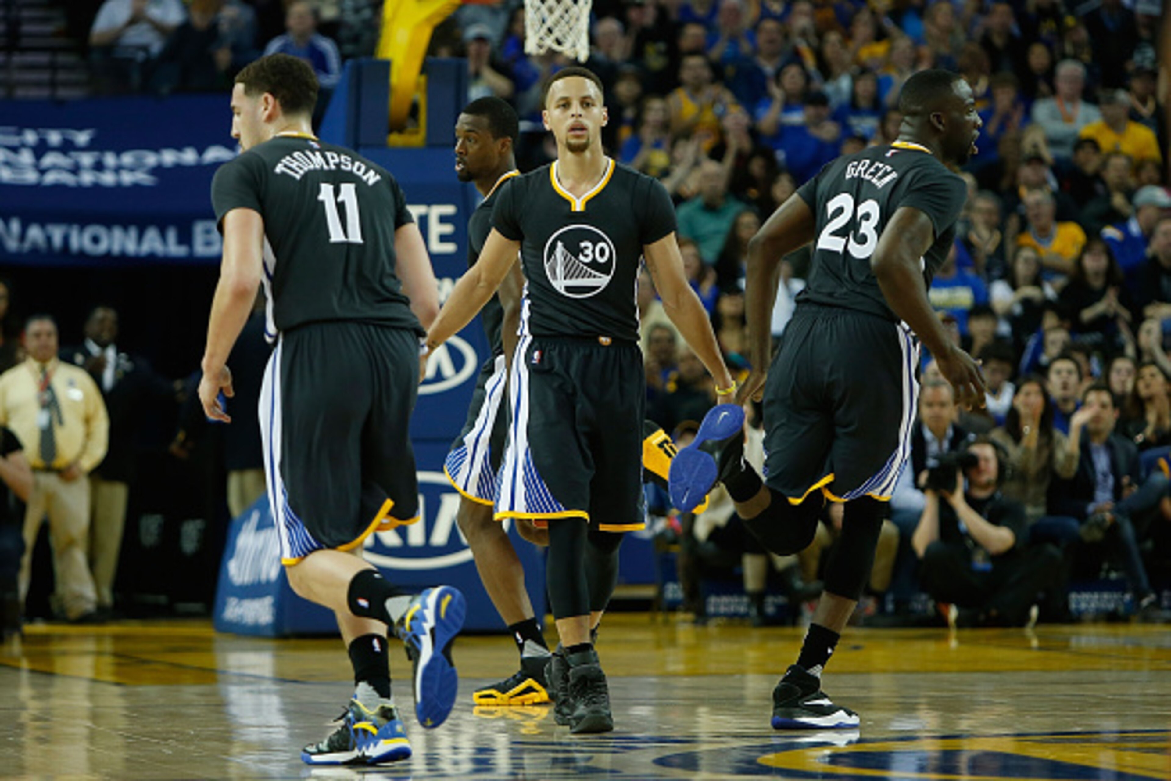 OAKLAND, CA - MARCH 12: Klay Thompson #11, Stephen Curry #30 and Draymond Green #23 of the Golden State Warriors celebrate a basket against the Phoenix Suns at ORACLE Arena on March 12, 2016 in Oakland, California. NOTE TO USER: User expressly acknowledge