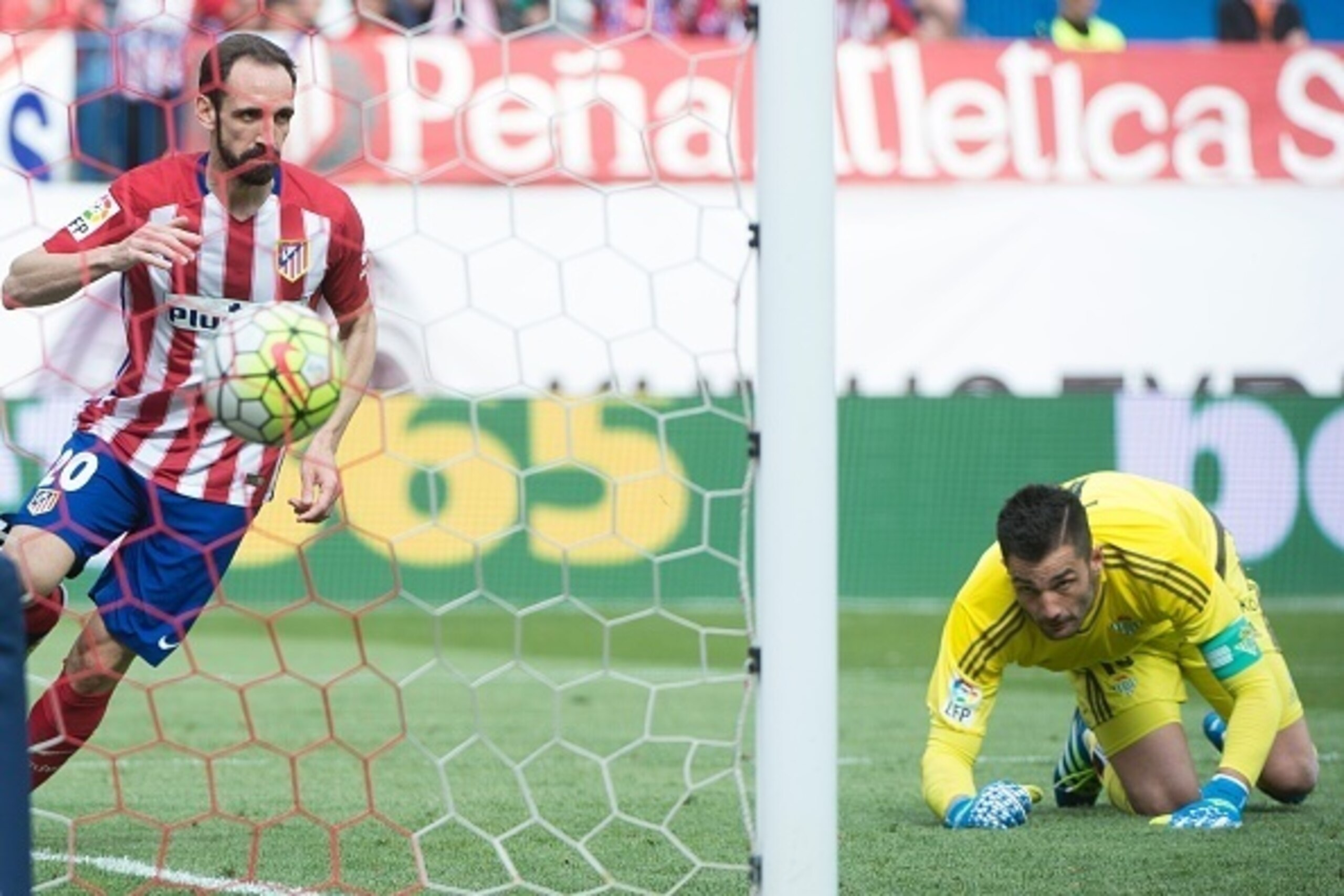 Atletico Madrid's defender Juanfran (L) scores during the Spanish league football match Club Atletico de Madrid vs Real Betis Balompi at the Vicente Calderon stadium in Madrid on April 2, 2016. / AFP / CURTO DE LA TORRE        (Photo credit should read CU