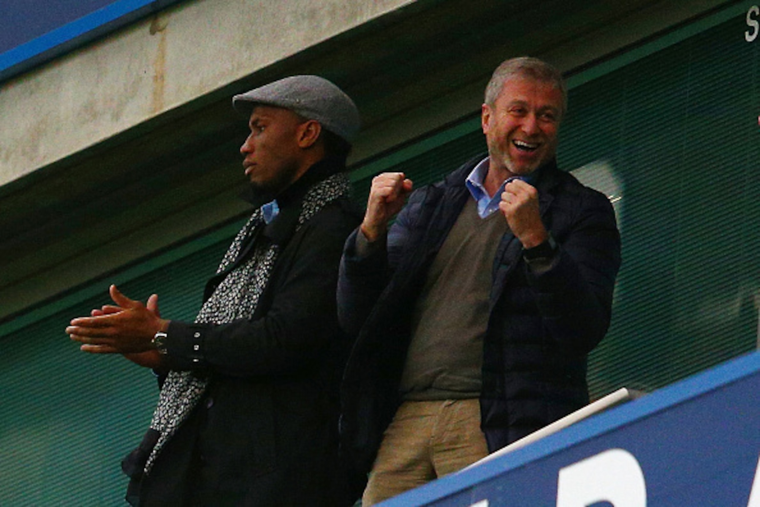 LONDON, ENGLAND - DECEMBER 19:  Didier Drogba (L) of Montreal Impact and Chelsea owner Roman Abramovich (R) celebrate Chelsea's second goal on the stand prior to the Barclays Premier League match between Chelsea and Sunderland at Stamford Bridge on Decemb