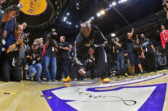LOS ANGELES, CA - APRIL 13:  Kobe Bryant #24 of the Los Angeles Lakers signs the court after the game against the Utah Jazz on April 13, 2016 at Staples Center in Los Angeles, California. NOTE TO USER: User expressly acknowledges and agrees that, by downl