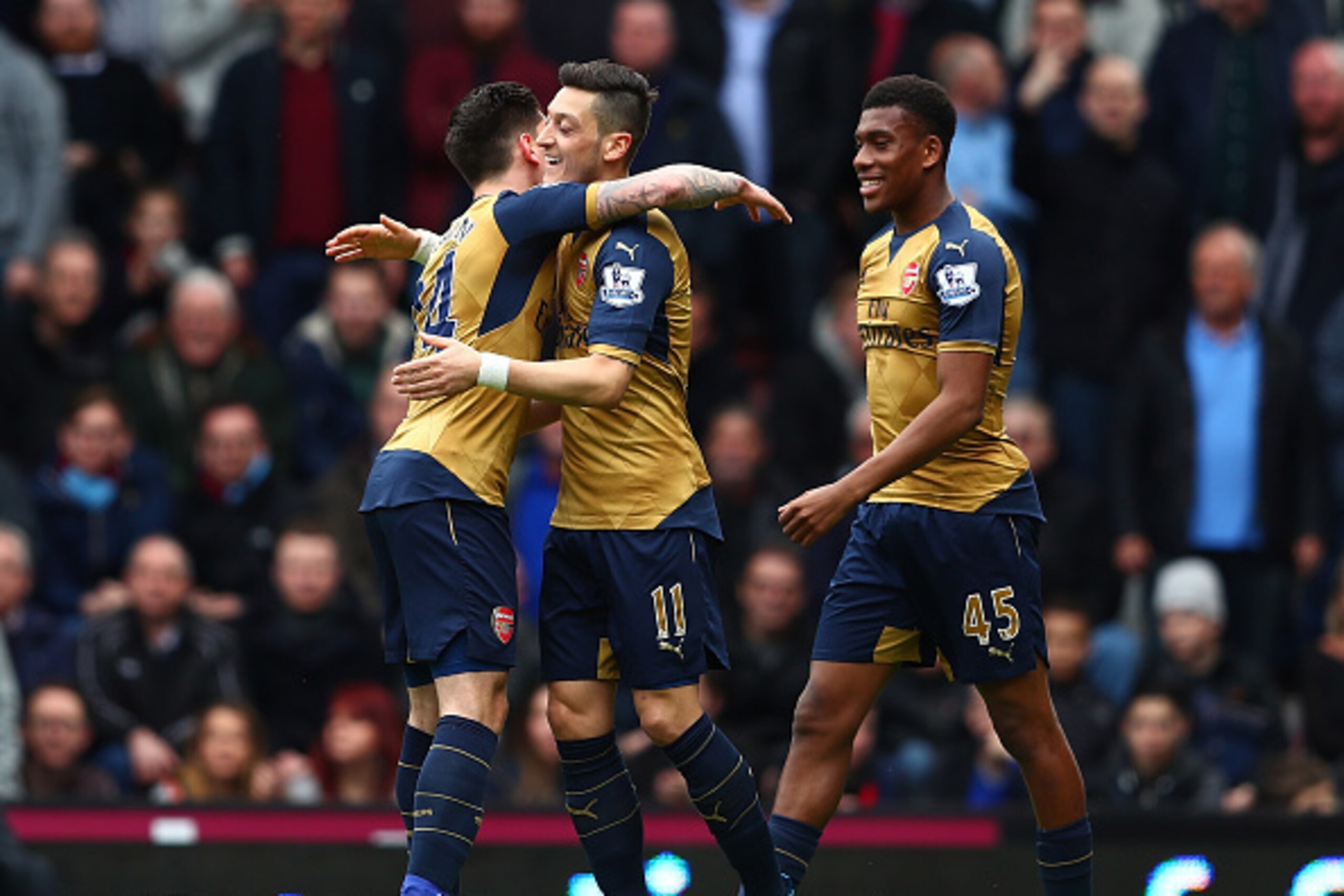 LONDON, UNITED KINGDOM - APRIL 09:  Mesut Ozil (C) of Arsenal celebrates scoring his team's first goal with his team mate Hector Bellerin (L) during the Barclays Premier League match between West Ham United and Arsenal at the Boleyn Ground on April 9, 201