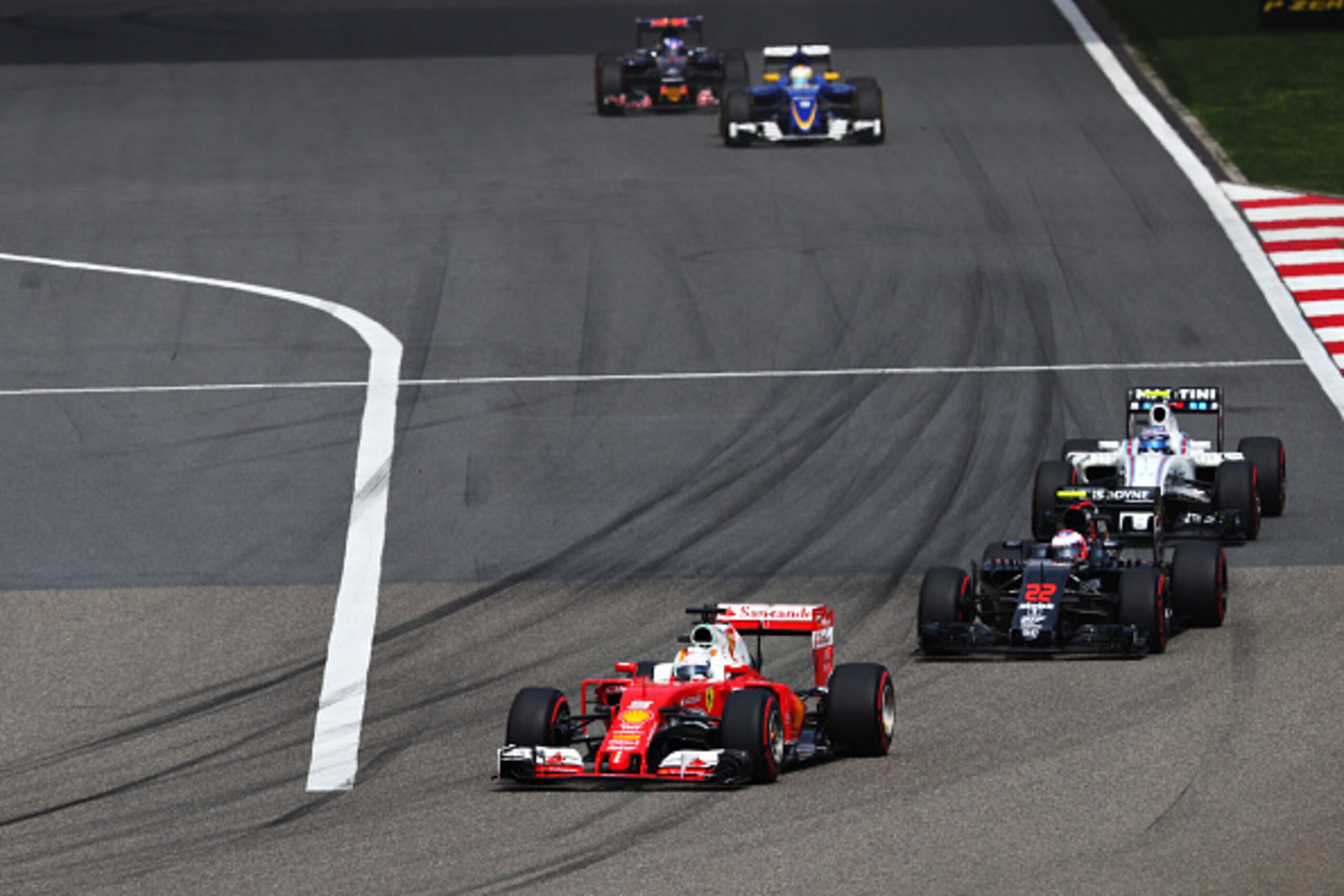 SHANGHAI, CHINA - APRIL 17: Sebastian Vettel of Germany driving the (5) Scuderia Ferrari SF16-H Ferrari 059/5 turbo (Shell GP) leads Jenson Button of Great Britain driving the (22) McLaren Honda Formula 1 Team McLaren MP4-31 Honda RA616H Hybrid turbo, and