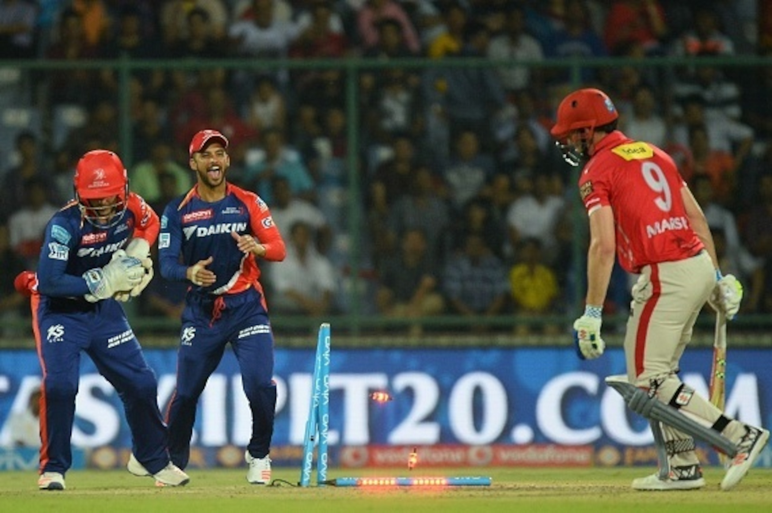 Kings XI Punjab batsman Shaun Marsh(R)is stumped by Delhi Daredevils wicketkeeper Quinton De Kock(L) as fielder JP Duminy(C) looks on during the 2016 Indian Premier League (IPL) Twenty20 cricket match between Delhi Daredevils and Kings XI Punjab at The Fe