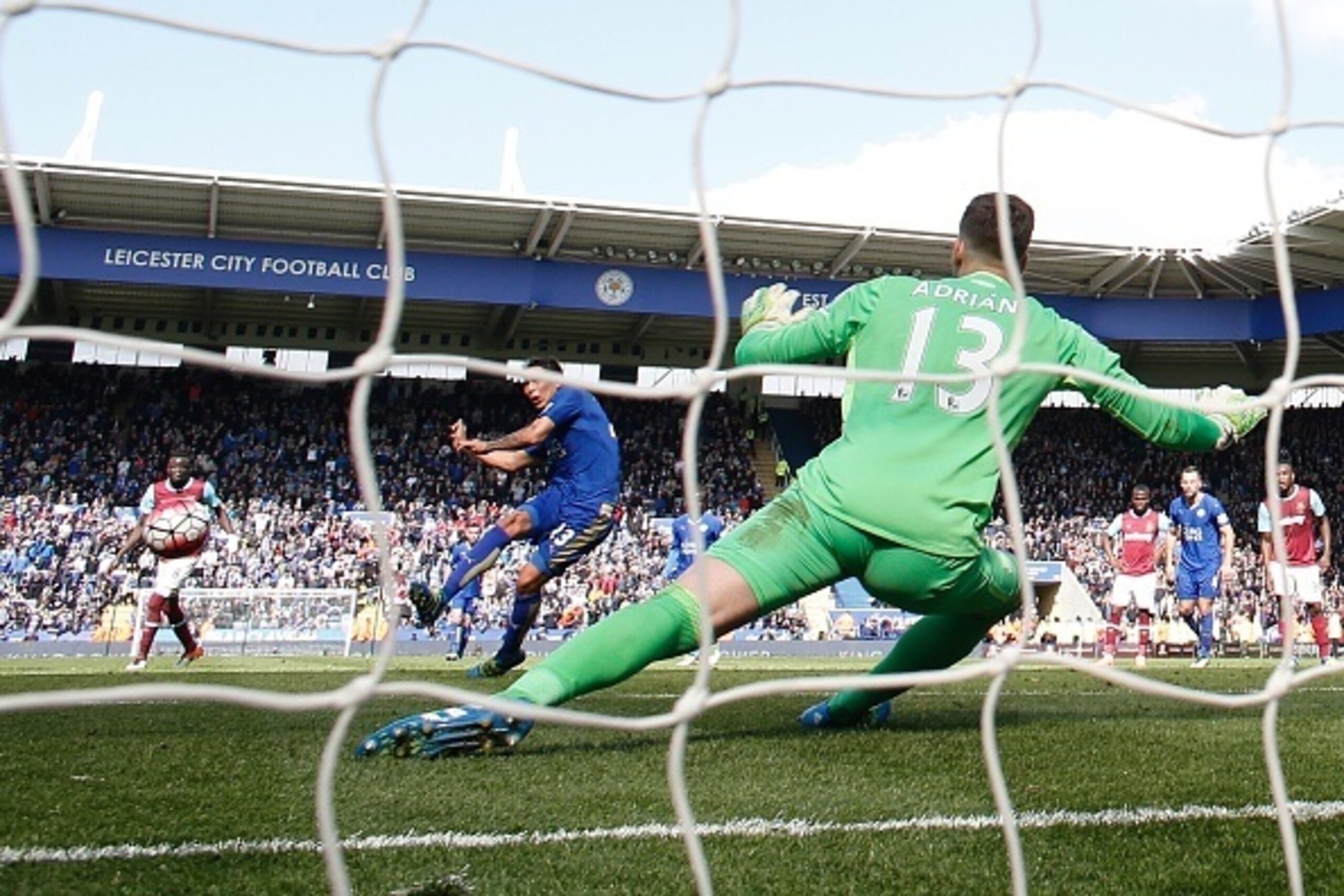 Leicester City's Argentinian striker Leonardo Ulloa (L) scores their second goal from the penalty spot to equalise 2-2 as West Ham United's Spanish goalkeeper Adrian (R) reacts during the English Premier League football match between Leicester City and We