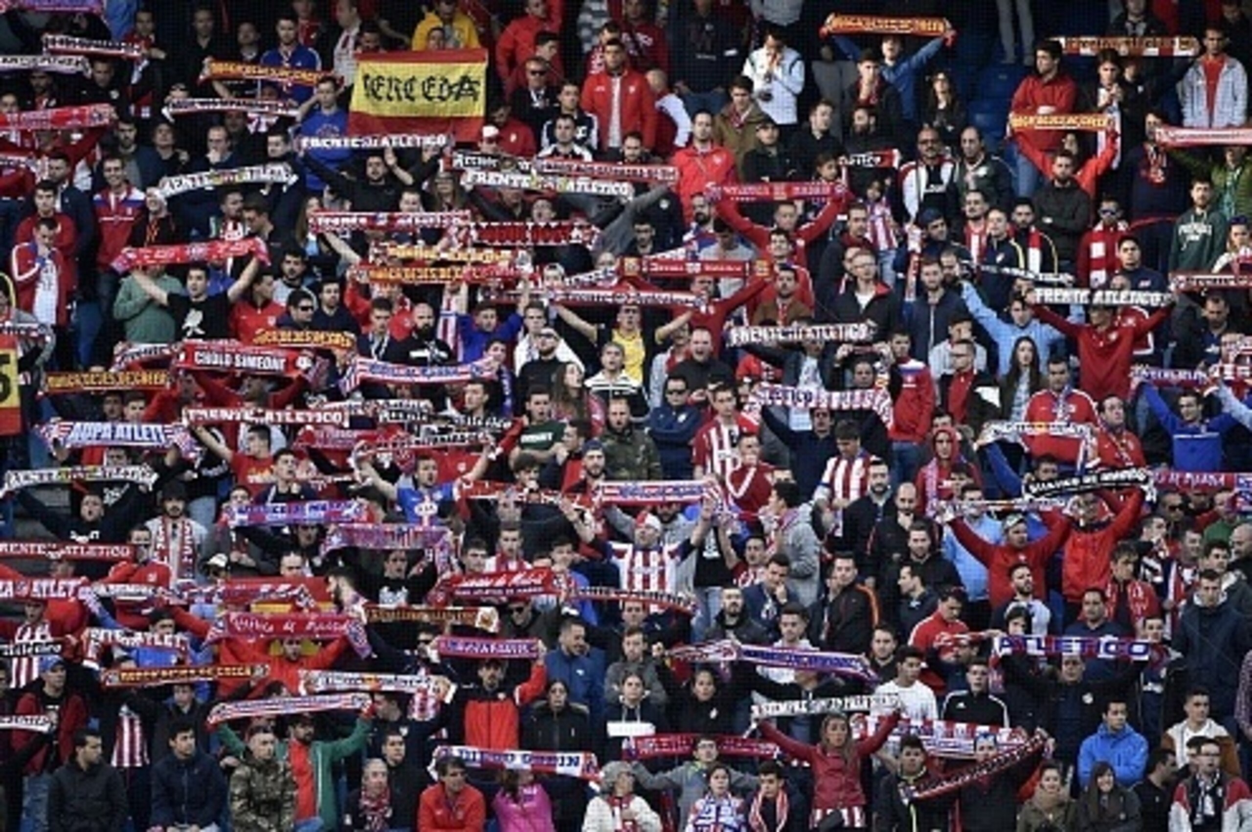 Atletico's footdball club supporters hold a club's scarves during the Spanish league football match Atletico de Madrid vs Granada CF at the Vicente Calderon stadium in Madrid on April 17, 2016. / AFP / GERARD JULIEN        (Photo credit should read GERARD
