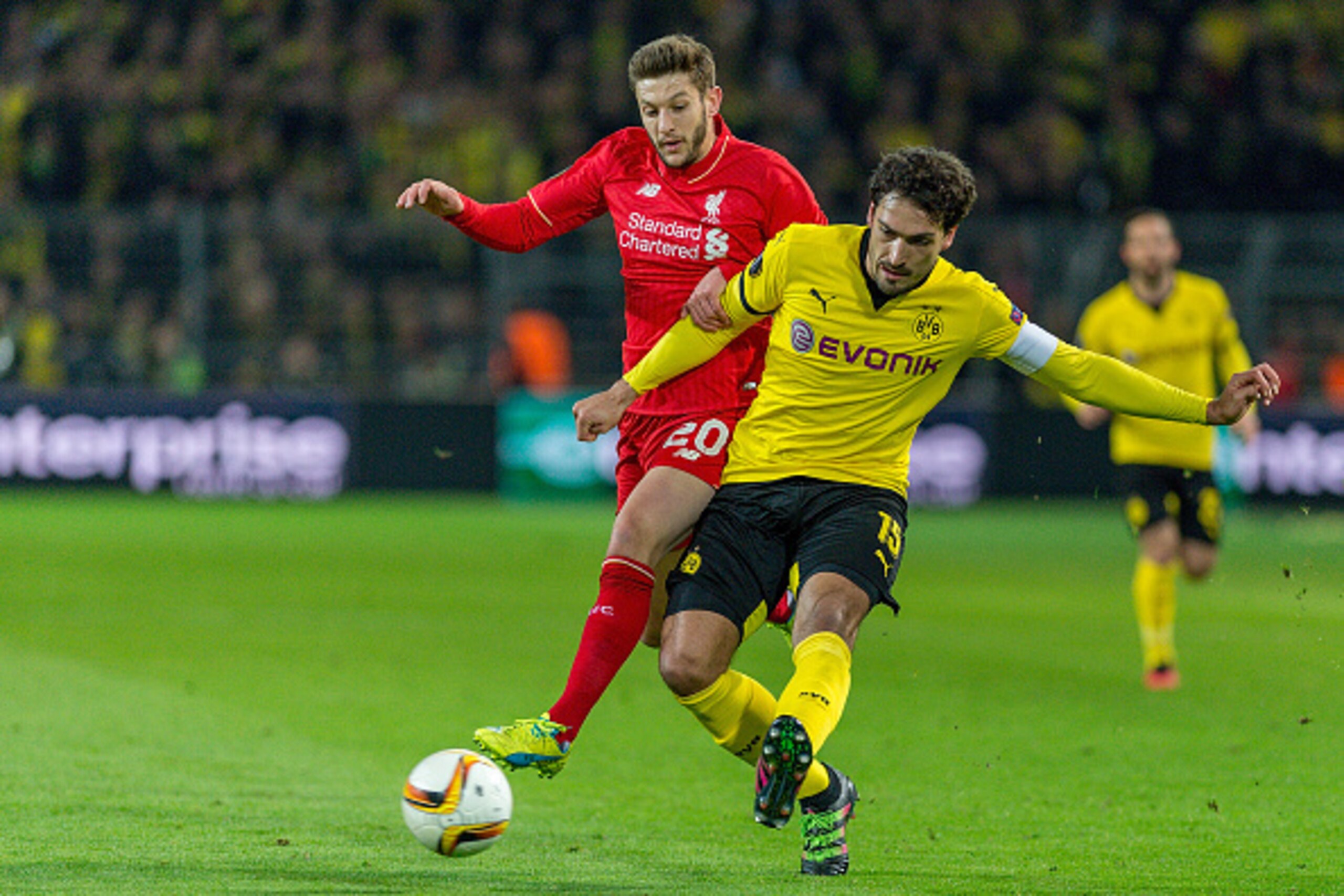 DORTMUND, GERMANY - APRIL 07: Defense Mats Hummels (15) of Borussia Dortmund passing the ball while Midfielder Adam Lallana (20) of FC Liverpool interfering at Signal Iduna Park during the UEFA Europa League quarter final first leg match between Borussia 