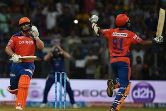 Gujarat Lions Aaron Finch (L) and Dhawal Kulkarni celebrate after the winning runs  during the 2016 Indian Premier League(IPL) Twenty20 cricket match between Gujarat Lions and Mumbai Indians at the Wankhede Stadium in Mumbai on April 16, 2016.  / AFP / IN
