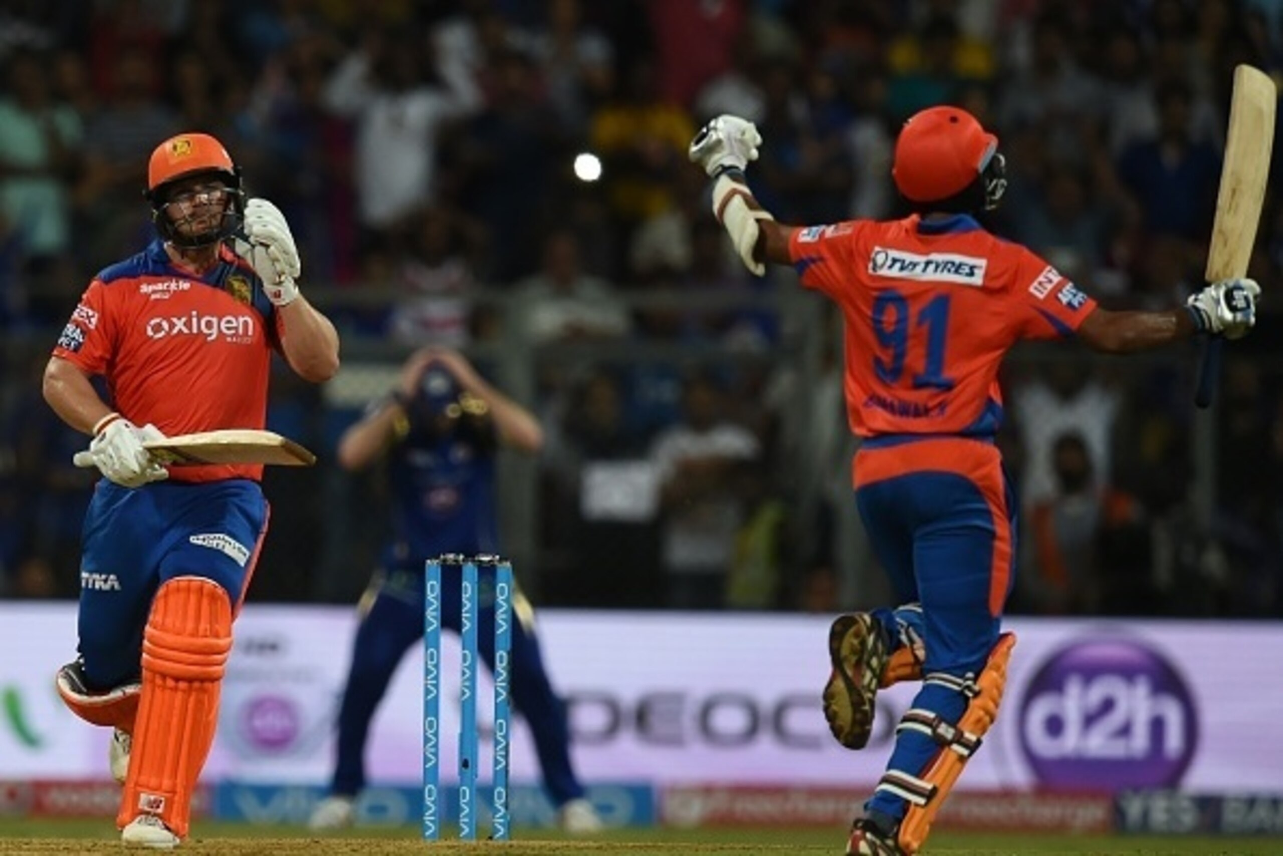 Gujarat Lions Aaron Finch (L) and Dhawal Kulkarni celebrate after the winning runs  during the 2016 Indian Premier League(IPL) Twenty20 cricket match between Gujarat Lions and Mumbai Indians at the Wankhede Stadium in Mumbai on April 16, 2016.  / AFP / IN