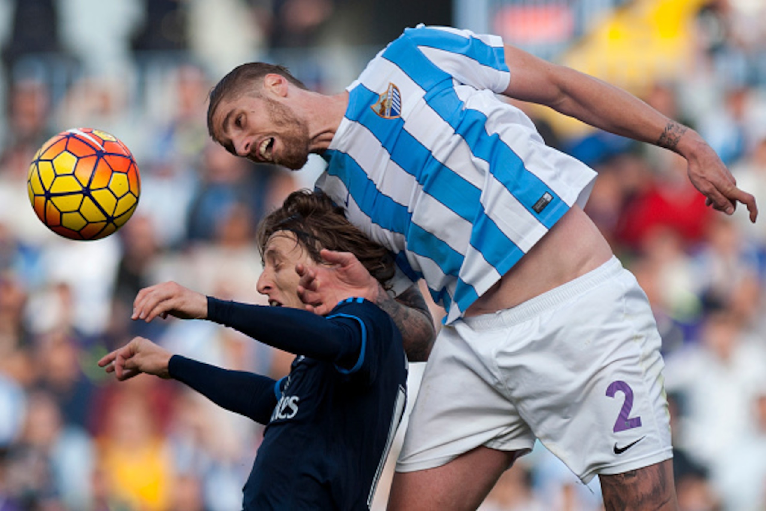 Real Madrid's Croatian midfielder Luka Modric (L) vies with Malaga's defender Raul Albentosa during the Spanish league football match Malaga CF vs Real Madrid CF at La Rosaleda stadium in Malaga on February 21, 2016.  / AFP / JORGE GUERRERO        (Photo 