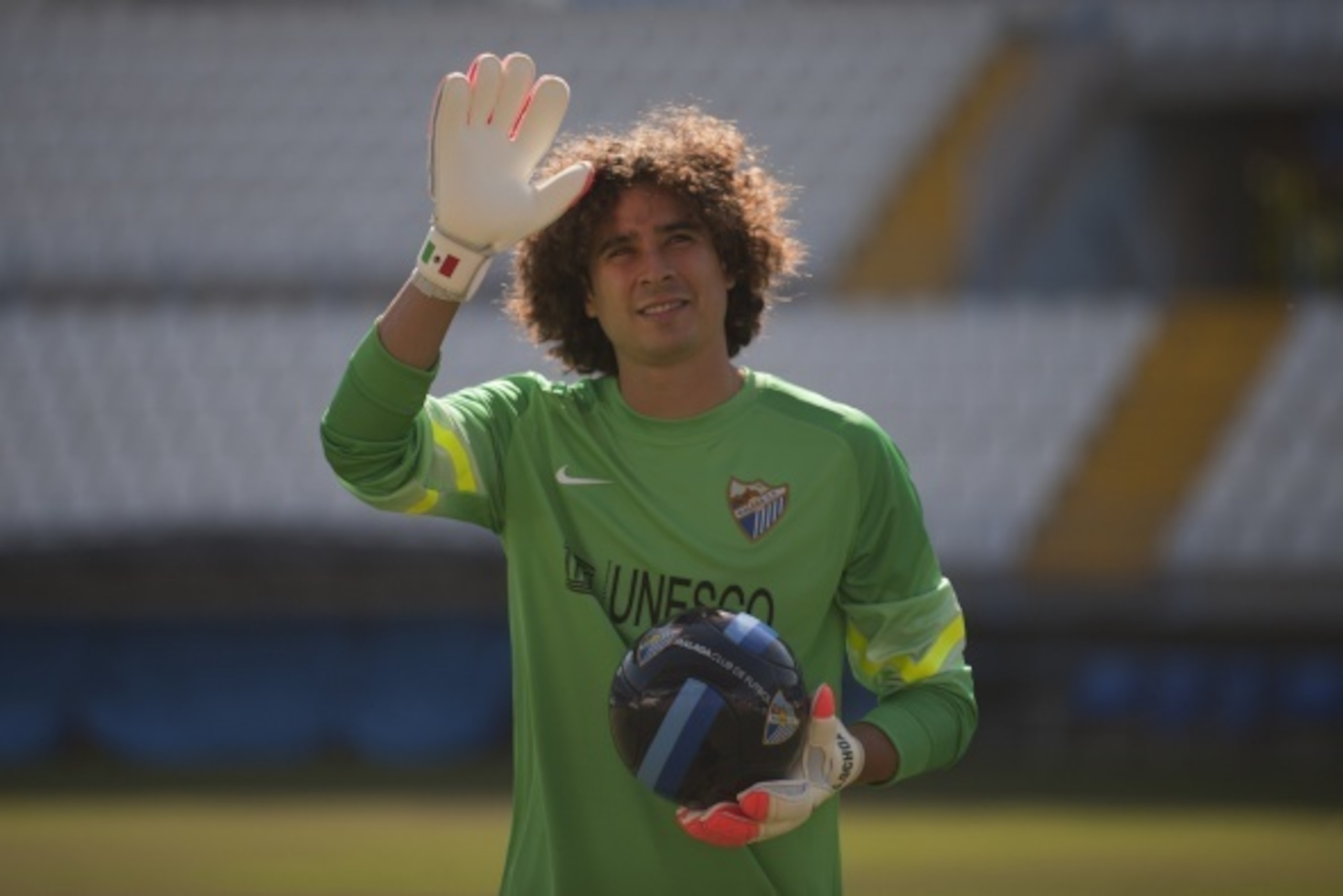 Malaga's new Mexican goalkeeper Guillermo Ochoa waves to supporters during his official presentation at the Rosaleda stadium in Malaga on August 1, 2014.   AFP PHOTO/ JORGE GUERRERO        (Photo credit should read Jorge Guerrero/AFP/Getty Images)