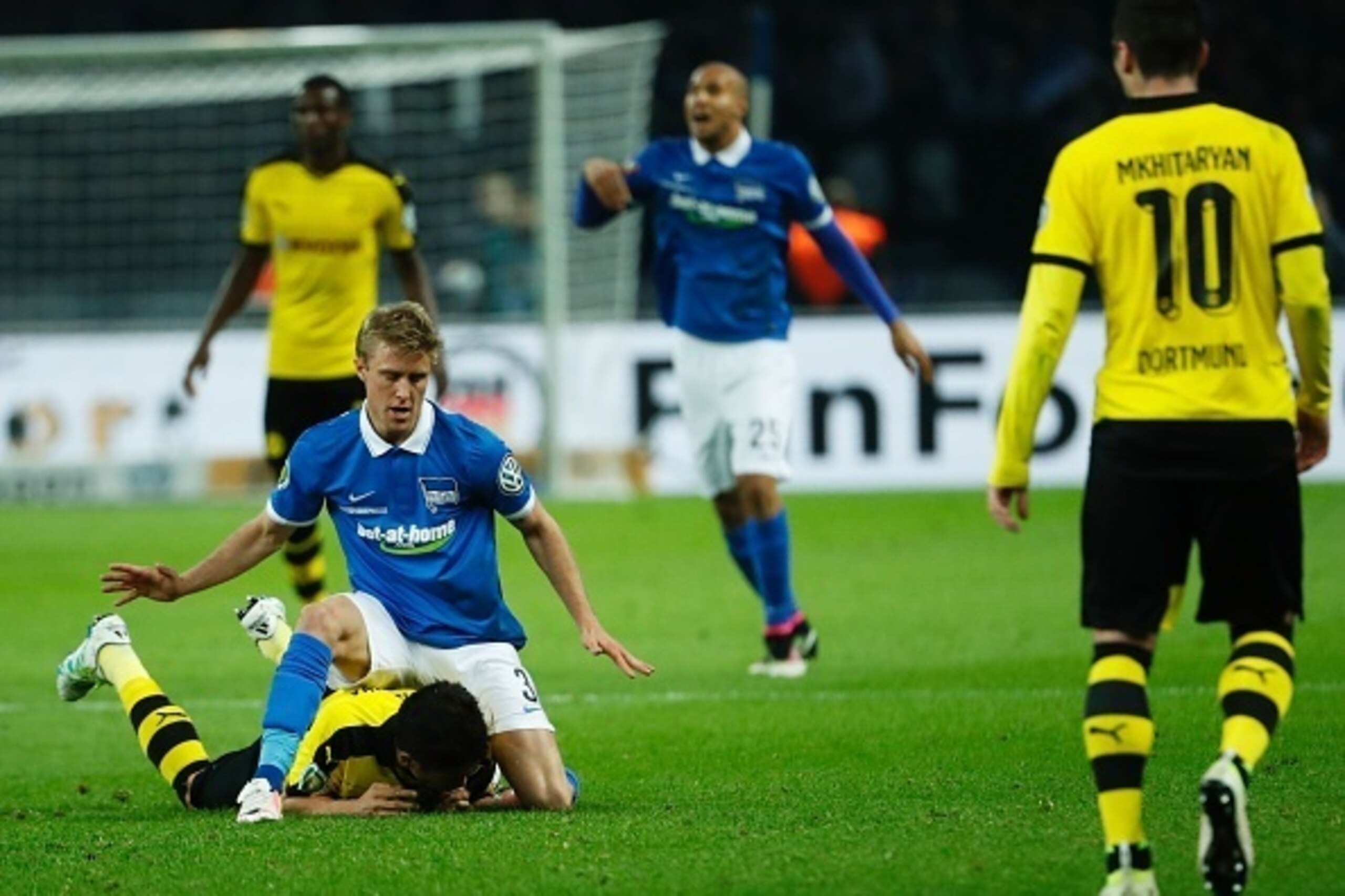 Hertha's Norwegian midfielder Per Ciljan Skjelbred (L) ends up on top of Dortmund's Japanese midfielder Shinji Kagawa  during the German Cup (DFB Pokal) semi-final football match Hertha Berlin v Borussia Dortmund at the Olympic stadium in Berlin on April 
