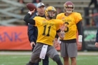 Jan 26, 2016; Mobile, AL, USA; North squad quarterback Carson Wentz of North Dakota State (11) throws a pass as North squad head coach Jason Garrett of the Dallas Cowboys (right) looks on during Senior Bowl practice at Ladd-Peebles Stadium. Mandatory Cred