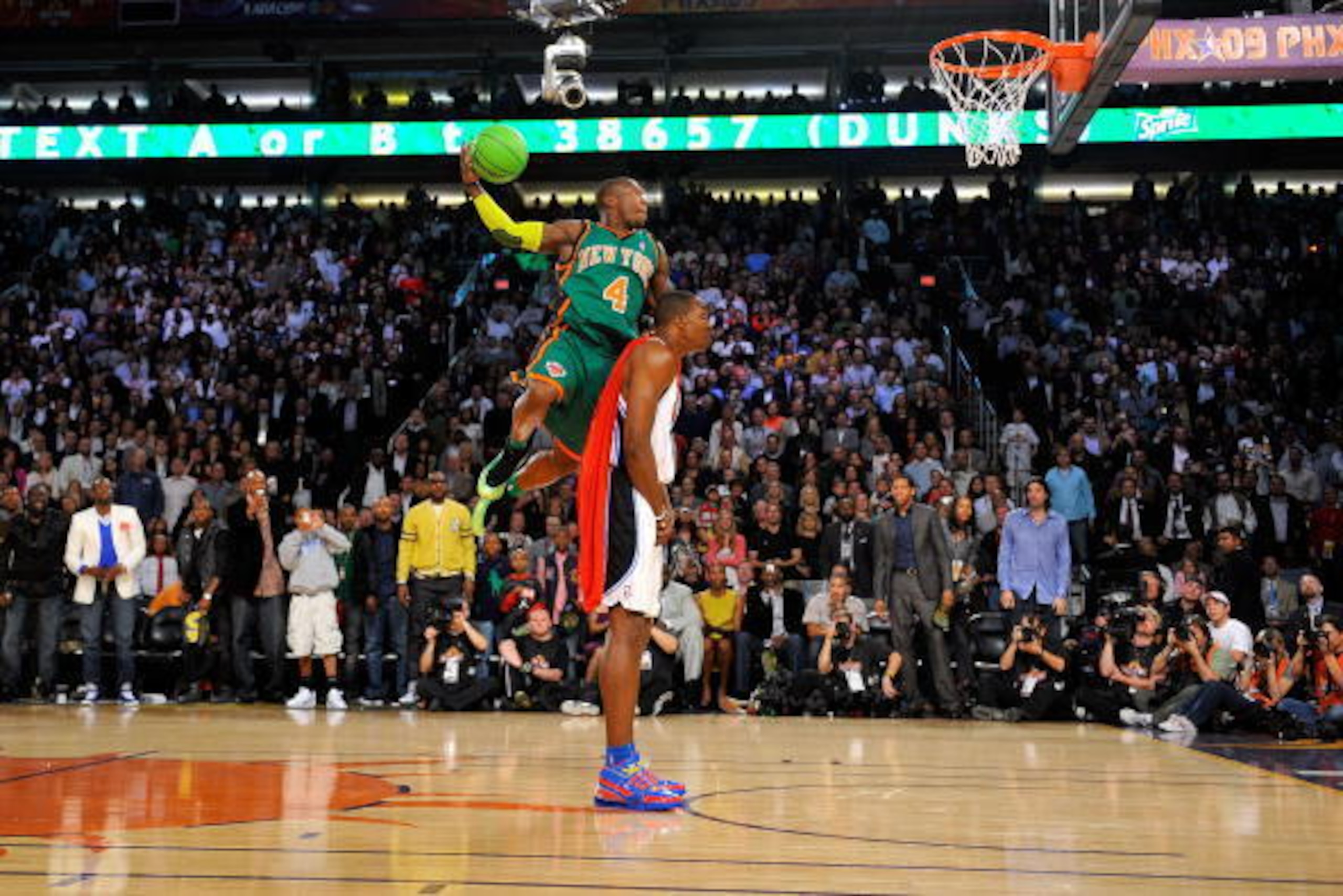 PHOENIX - FEBRUARY 14:  (Sequence 3 of 6) Nate Robinson #4 of the New York Knicks jumps over Dwight Howard #12 of the Orlando Magic on a dunk attempt during the Sprite Slam Dunk Contest on All-Star Saturday Night, part of 2009 NBA All-Star Weekend at US A