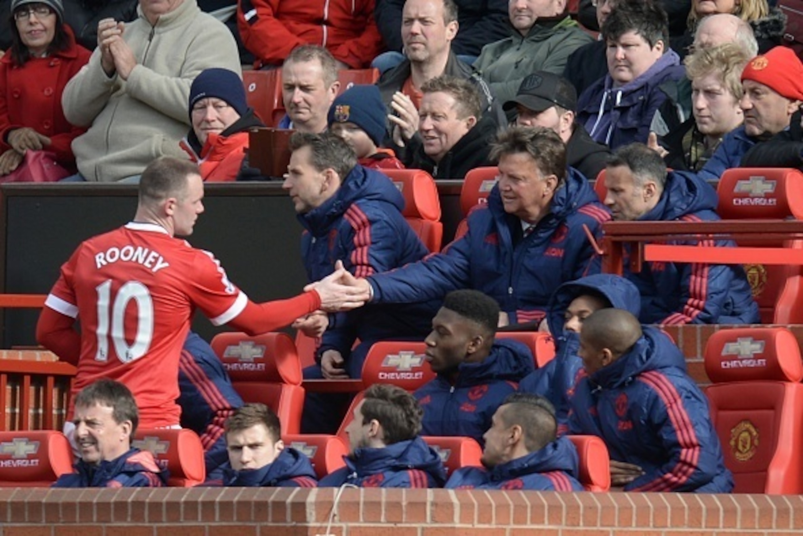 Manchester United's English striker Wayne Rooney (L) shakes hands with Manchester United's Dutch manager Louis van Gaal (2R) after he is substituted during the English Premier League football match between Manchester United and Aston Villa at Old Trafford