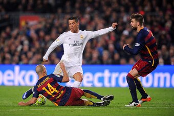 BARCELONA, SPAIN - APRIL 02:  Cristiano Ronaldo of Real Madrid CF attempts to shoot under pressure from Javier Mascherano and Gerard Pique of FC Barcelona during the La Liga match between FC Barcelona and Real Madrid CF at Camp Nou on April 2, 2016 in Bar