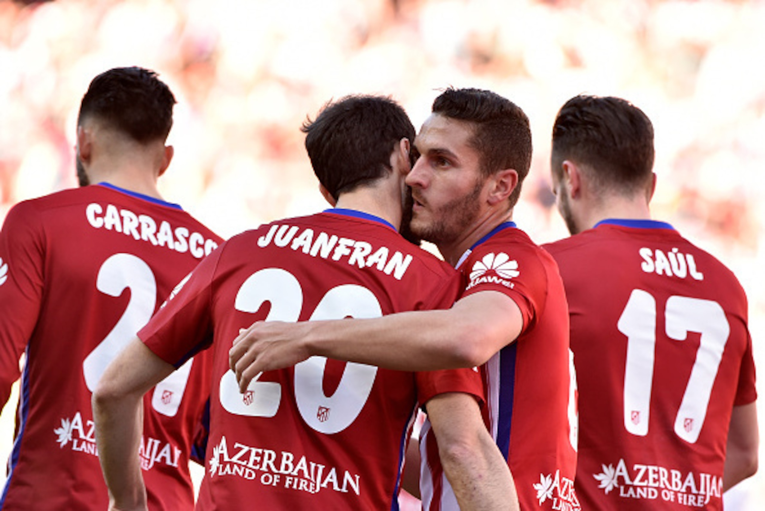 Atletico Madrid's midfielder Koke kisses Atletico Madrid's defender Juanfran after scoring during the Spanish league football match Atletico de Madrid vs Granada CF at the Vicente Calderon stadium in Madrid on April 17, 2016. / AFP / GERARD JULIEN        
