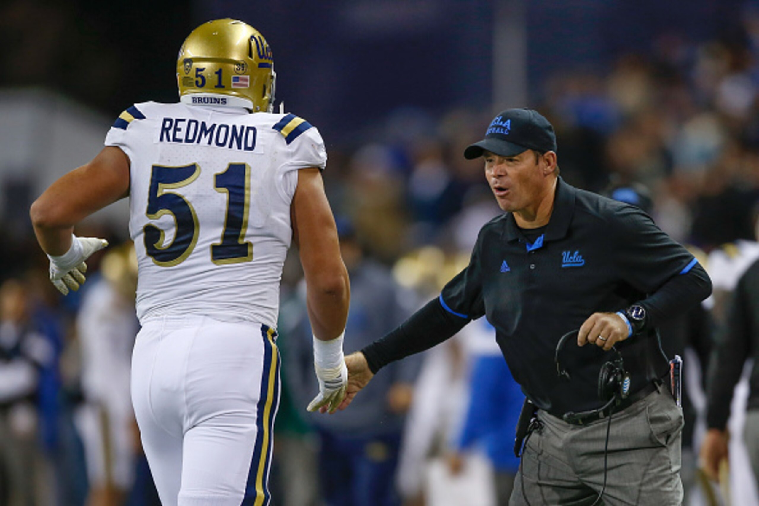 SEATTLE, WA - NOVEMBER 08:  Head coach Jim Mora of the UCLA Bruins congratulates Alex Redmond #51 after the Bruins scored a touchdown in the first half against the Washington Huskies on November 8, 2014 at Husky Stadium in Seattle, Washington. The Bruins 
