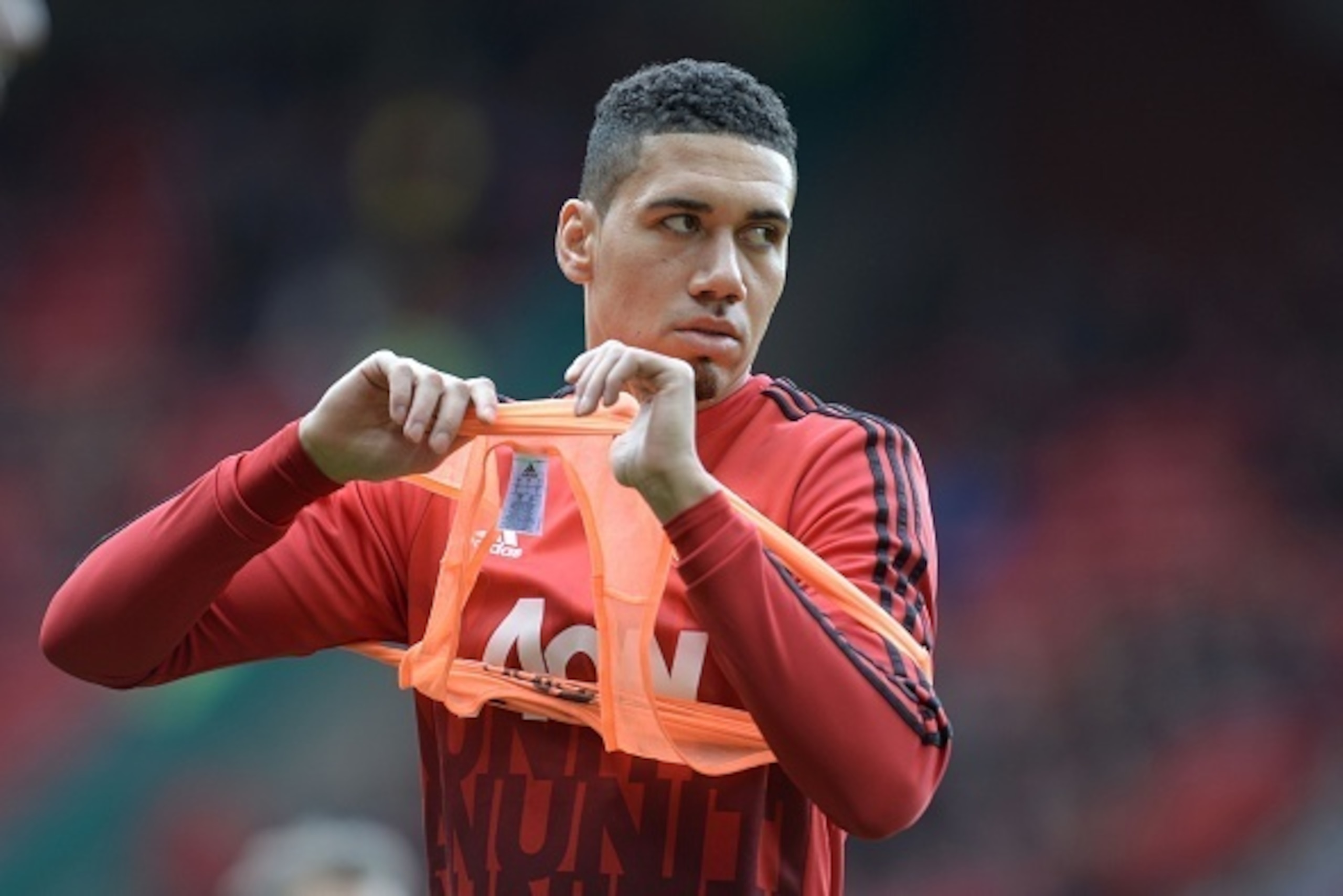 Manchester United's English defender Chris Smalling warms up before kick off of the English Premier League football match between Manchester United and Aston Villa at Old Trafford in Manchester, north west England, on April 16, 2016. / AFP / OLI SCARFF / 