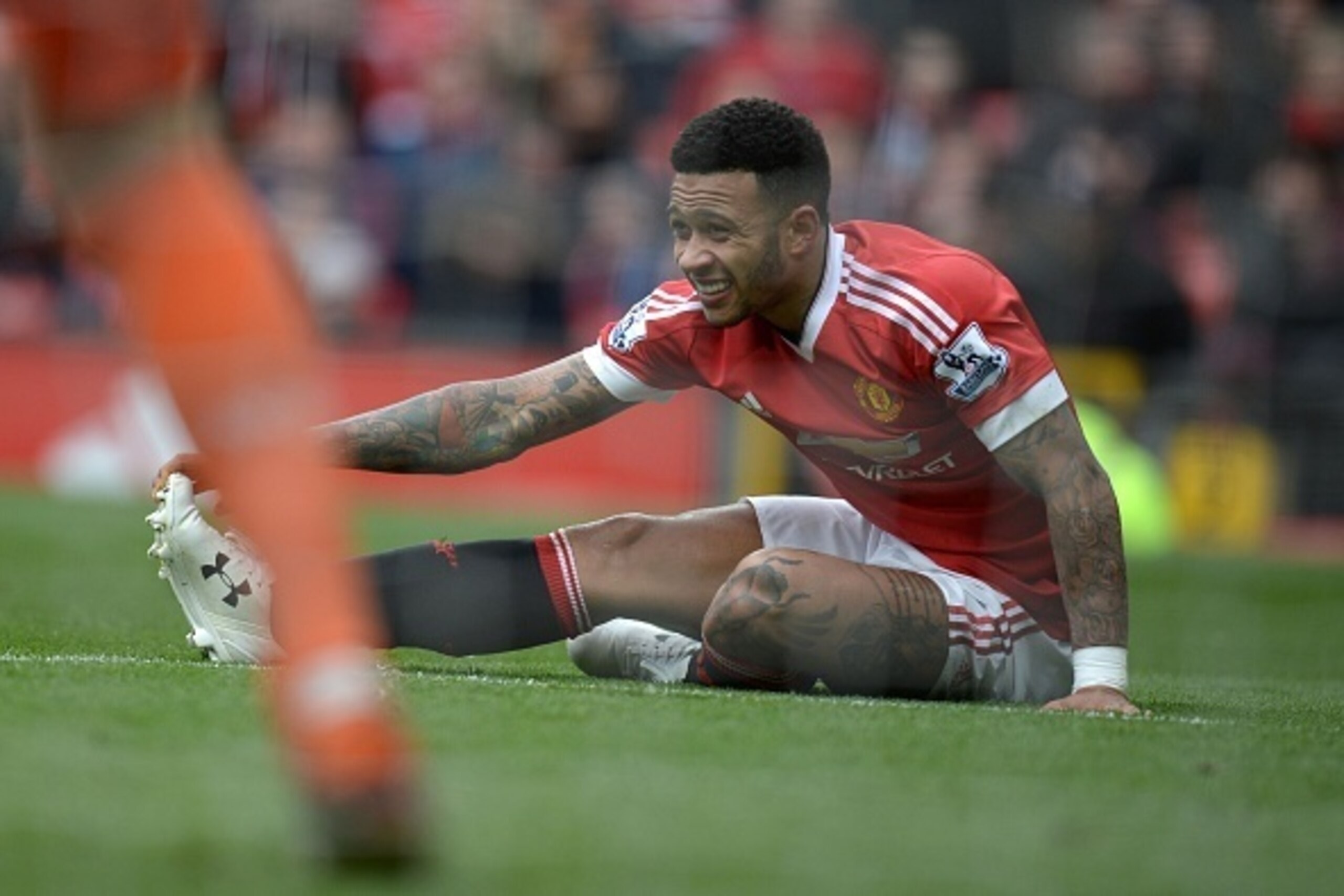 Manchester United's Dutch midfielder Memphis Depay stretches on the pitch during the English Premier League football match between Manchester United and Aston Villa at Old Trafford in Manchester, north west England, on April 16, 2016. / AFP / OLI SCARFF /